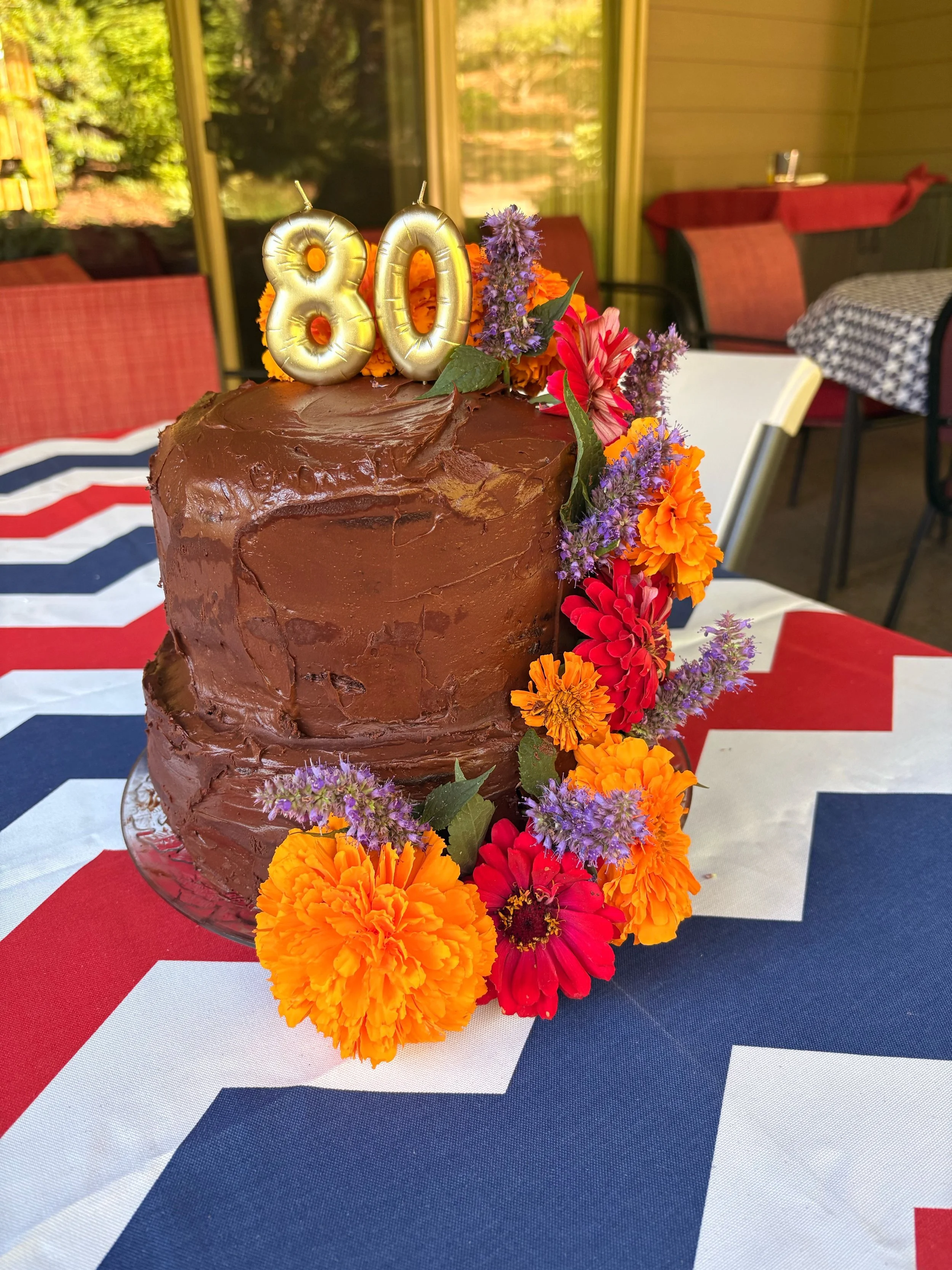 Two tier chocolate cake with espresso and chocolate ganache buttercream, edible flowers, for my mom&rsquo;s 80th party. She often denies herself the joys of eating decadent things so this felt appropriate: if you&rsquo;re not going to enjoy the best 