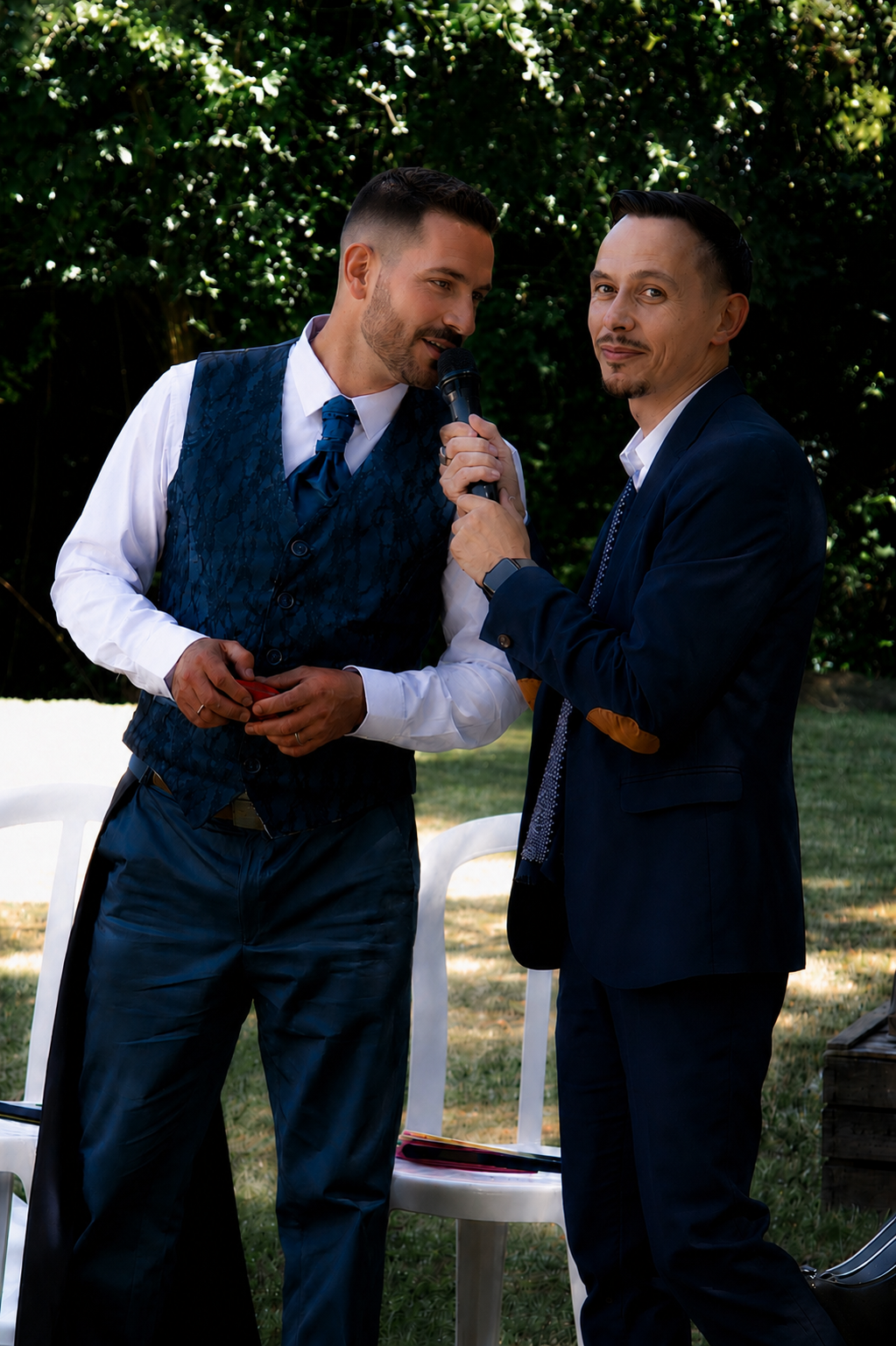 Quentin Glaud, officiant de cérémonie laïque échange avec le marié lors d'une cérémonie de mariage en extérieur.