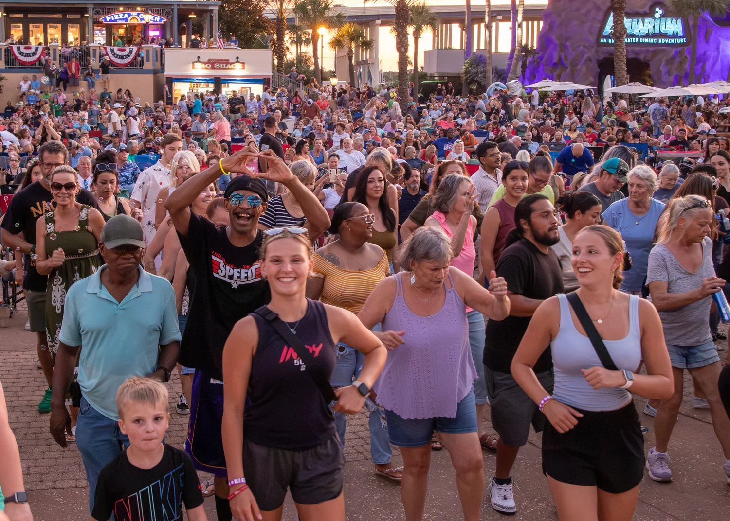 Crowd enjoying an evening outdoor concert at Rock the Dock at Kemah Boardwalk.