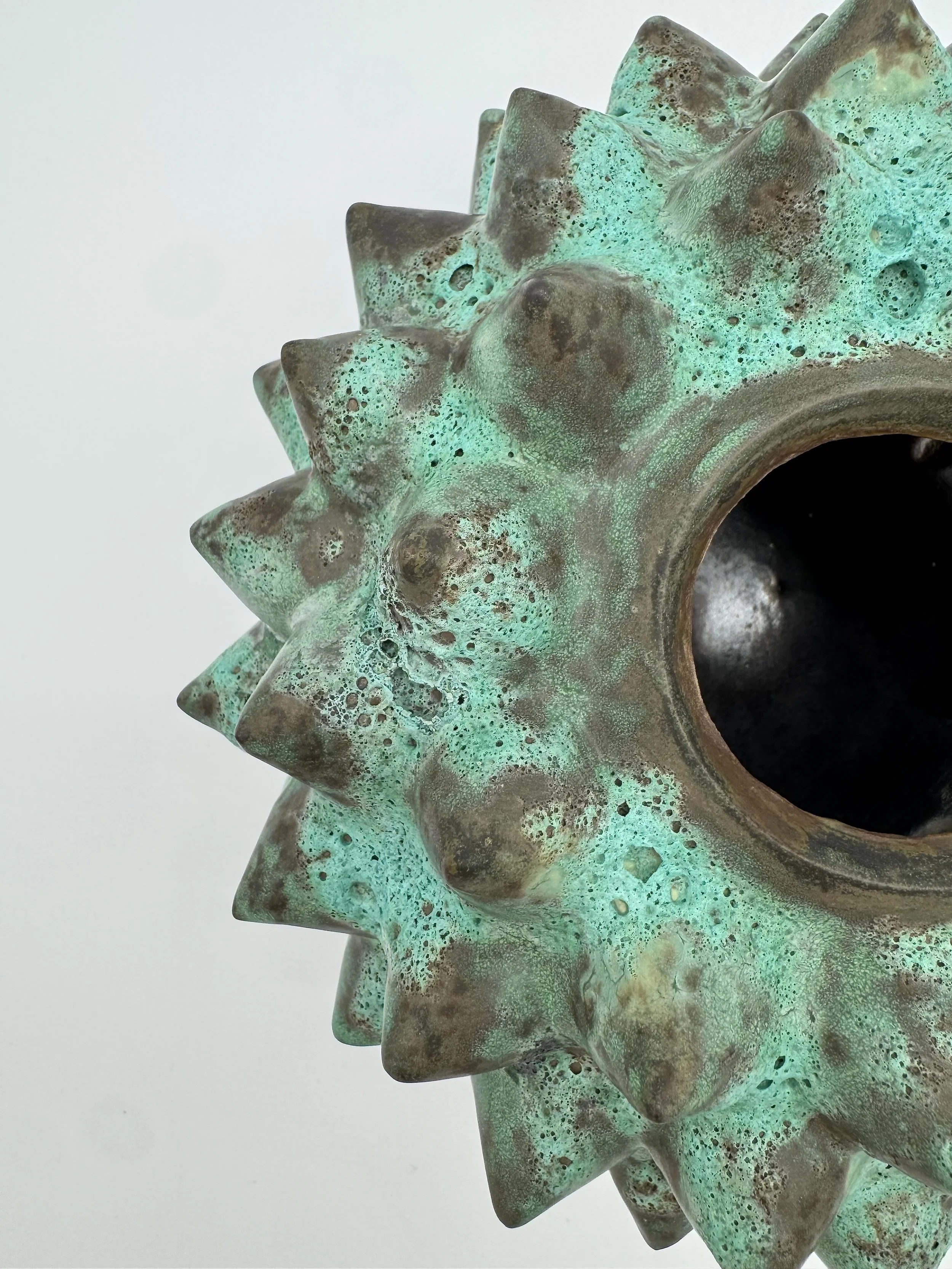 Close-up of a bronze or copper gear with a green patina.