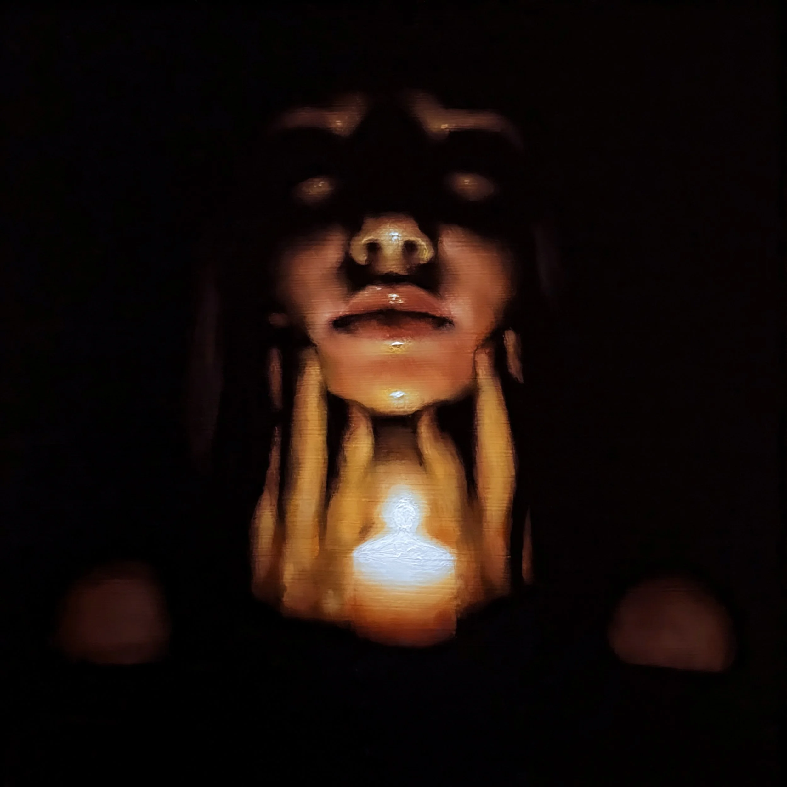 A dark image with a human face illuminated faintly, showing eyes, nose, and mouth, creating a mysterious or eerie atmosphere.