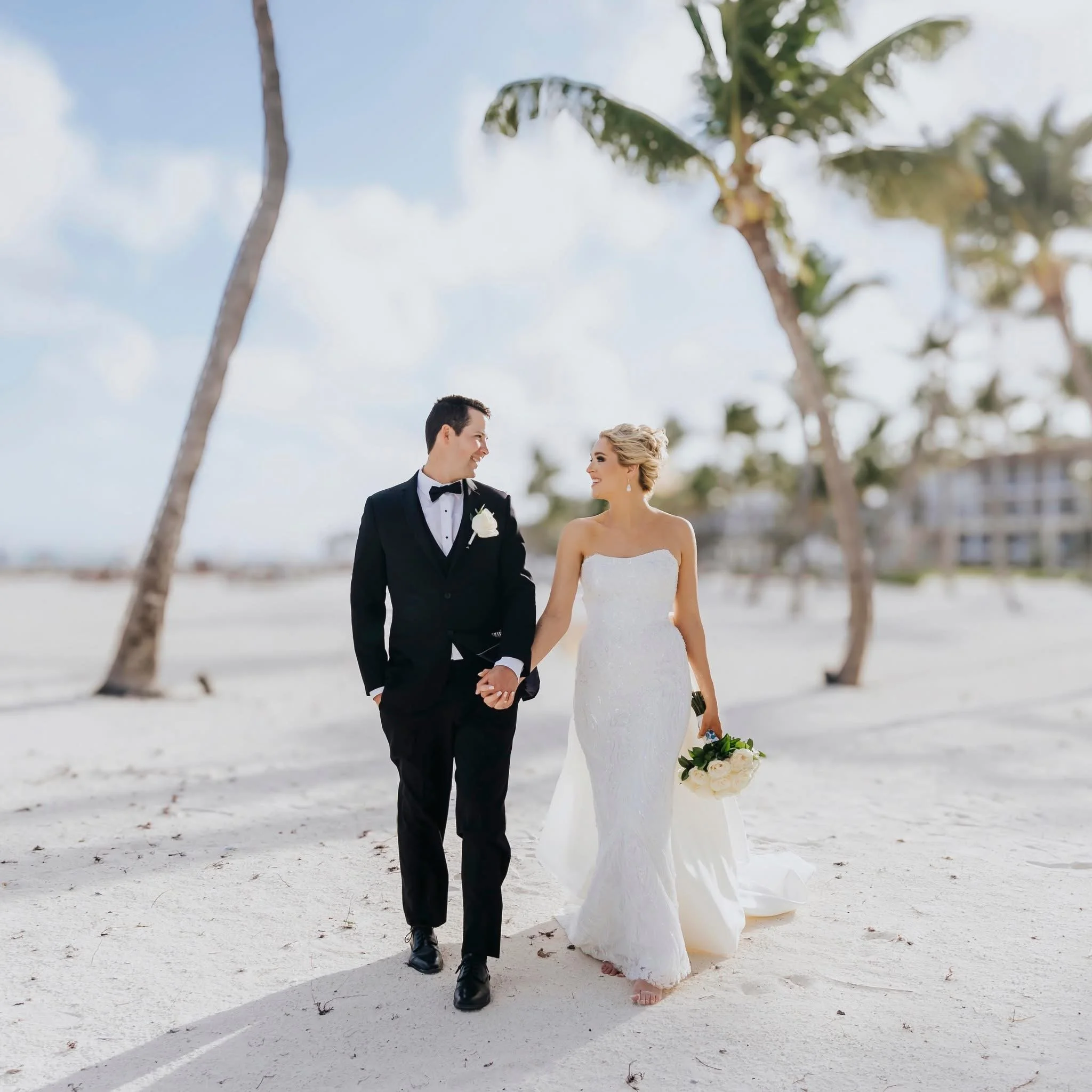 A bride and groom walking on a beach celebrating their wedding at Hyatt Ziva Cap Cana