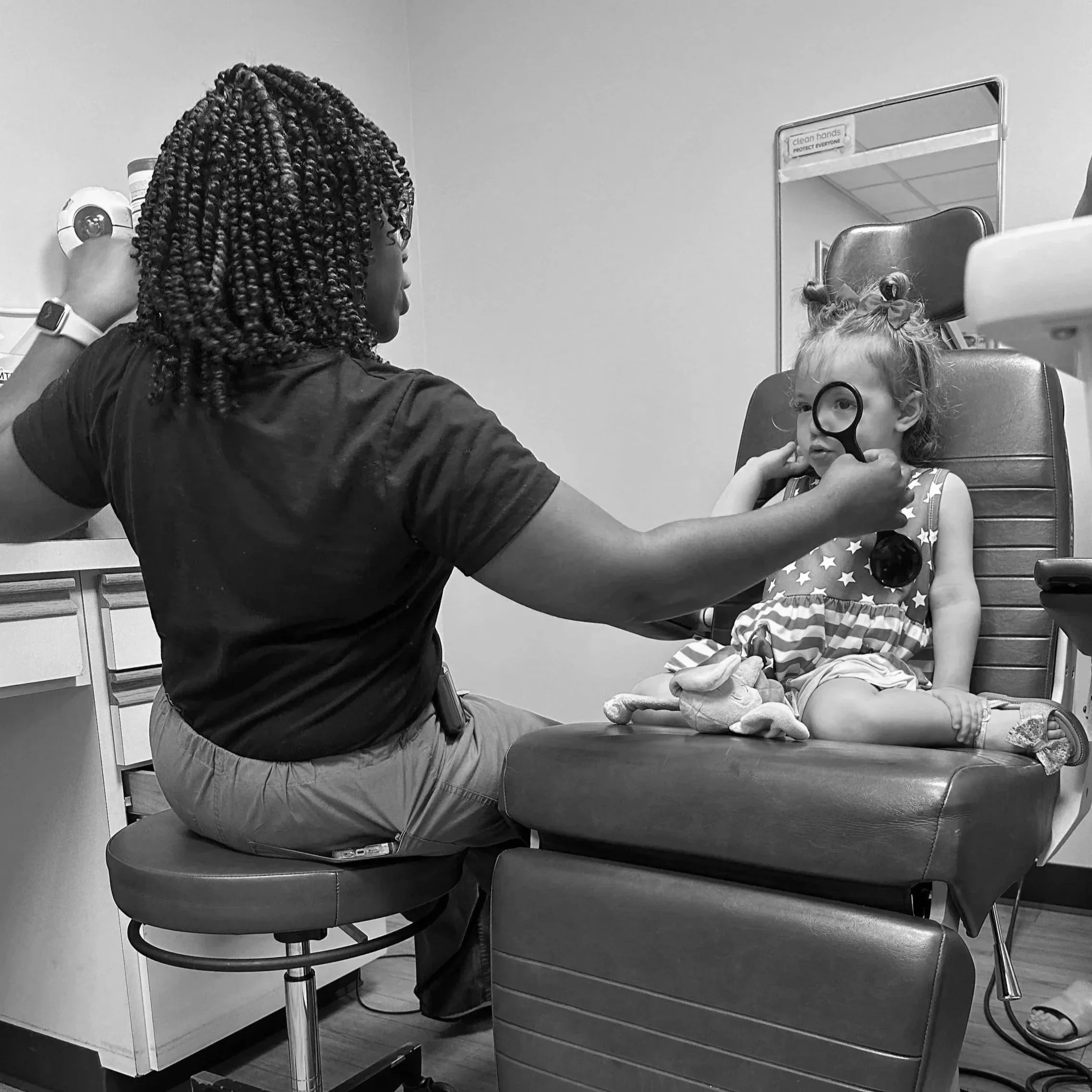 A healthcare worker in a medical setting with a young child with EB, treating them for an eye abrasion.
