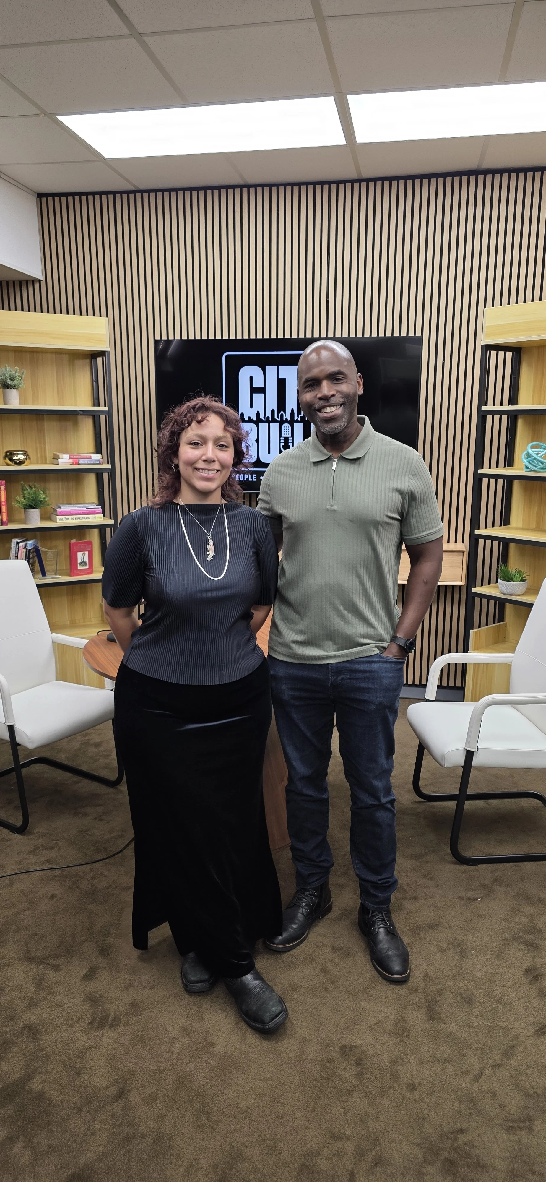 Irvans Augustin and a guest standing together in the City Built recording studio