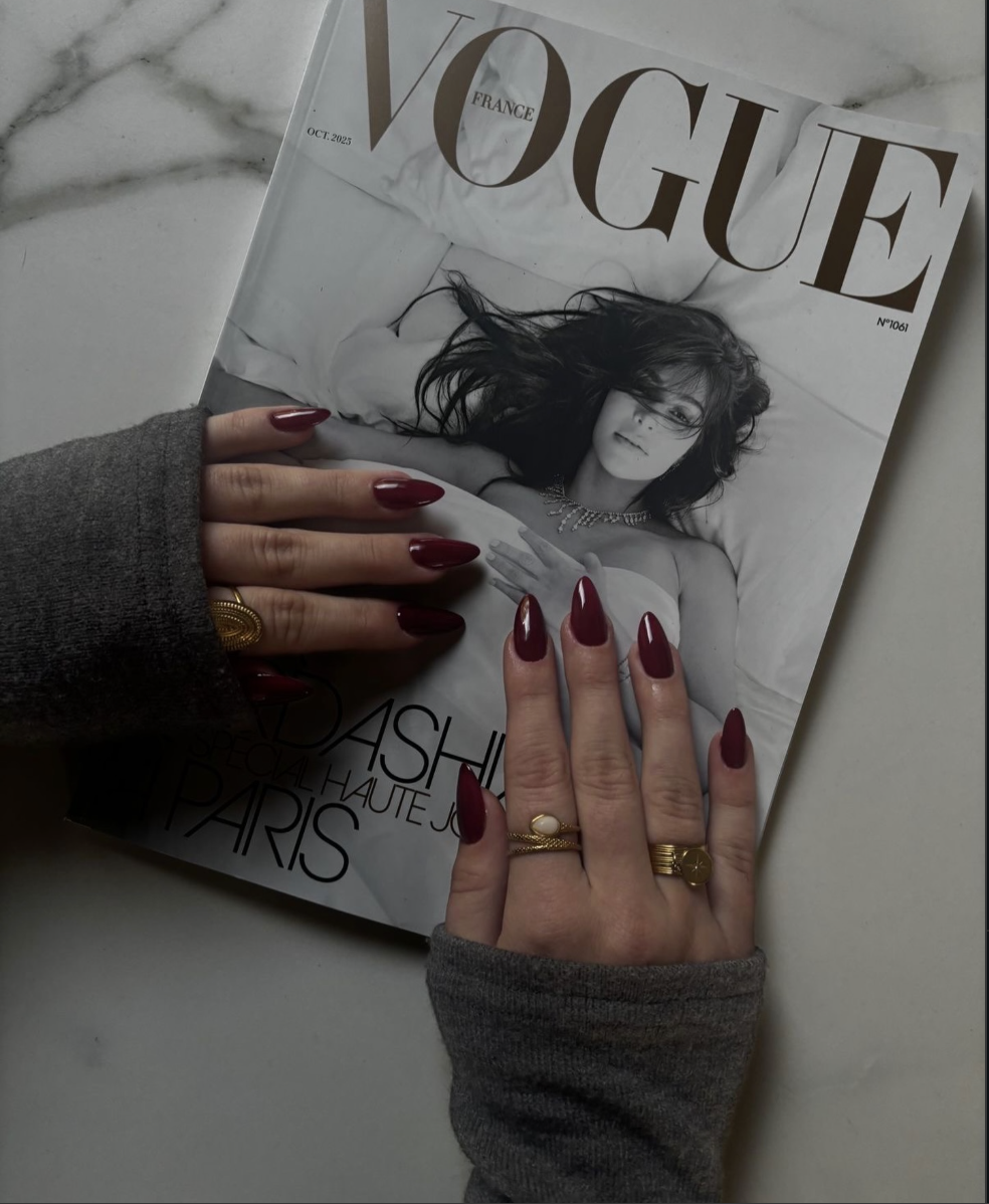 hand holding Coco Chanel perfume bottle with red nails