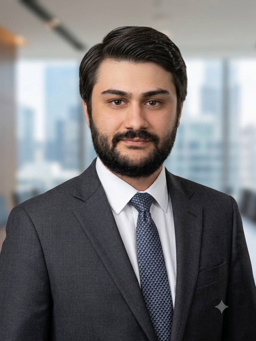 Professional man in a suit and tie standing in an office with city view windows in the background.