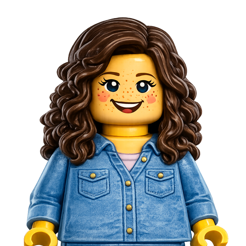 LEGO minifigure with brown curly hair, blue eyes, freckles, wearing a denim jacket, smiling with an open mouth.