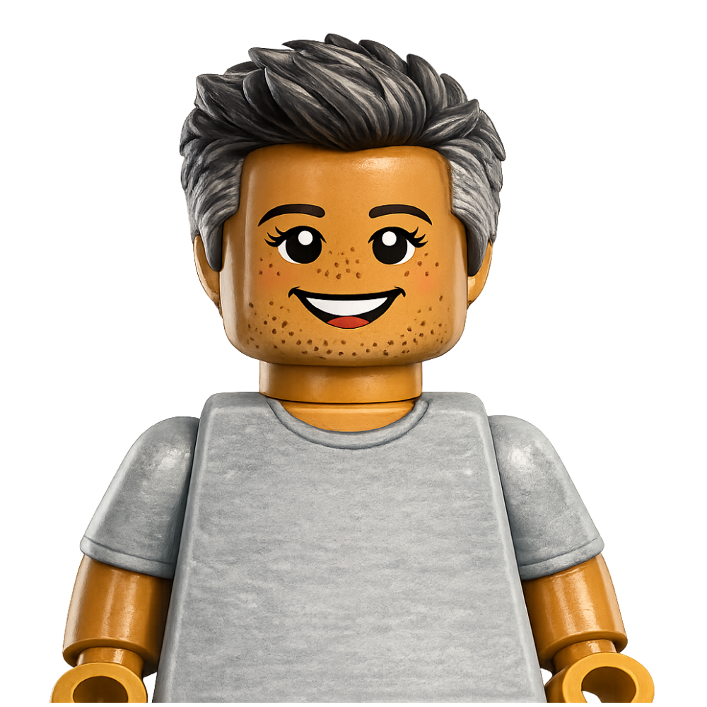 LEGO mini-figure of a smiling person with tan skin, black eyebrows, gray hair, and freckles, wearing a light gray shirt.