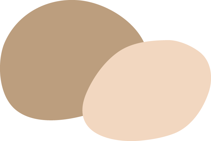 Two beige eggs, one slightly darker, placed on a light surface.