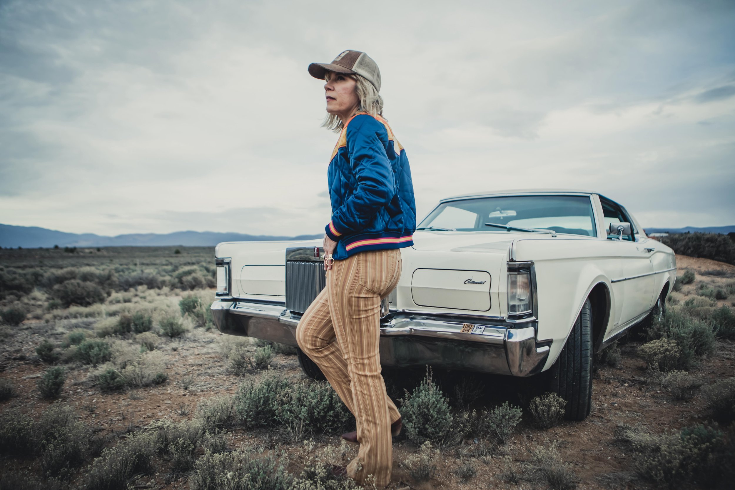 Musician Amanda Pearcy standing outside next to old car
