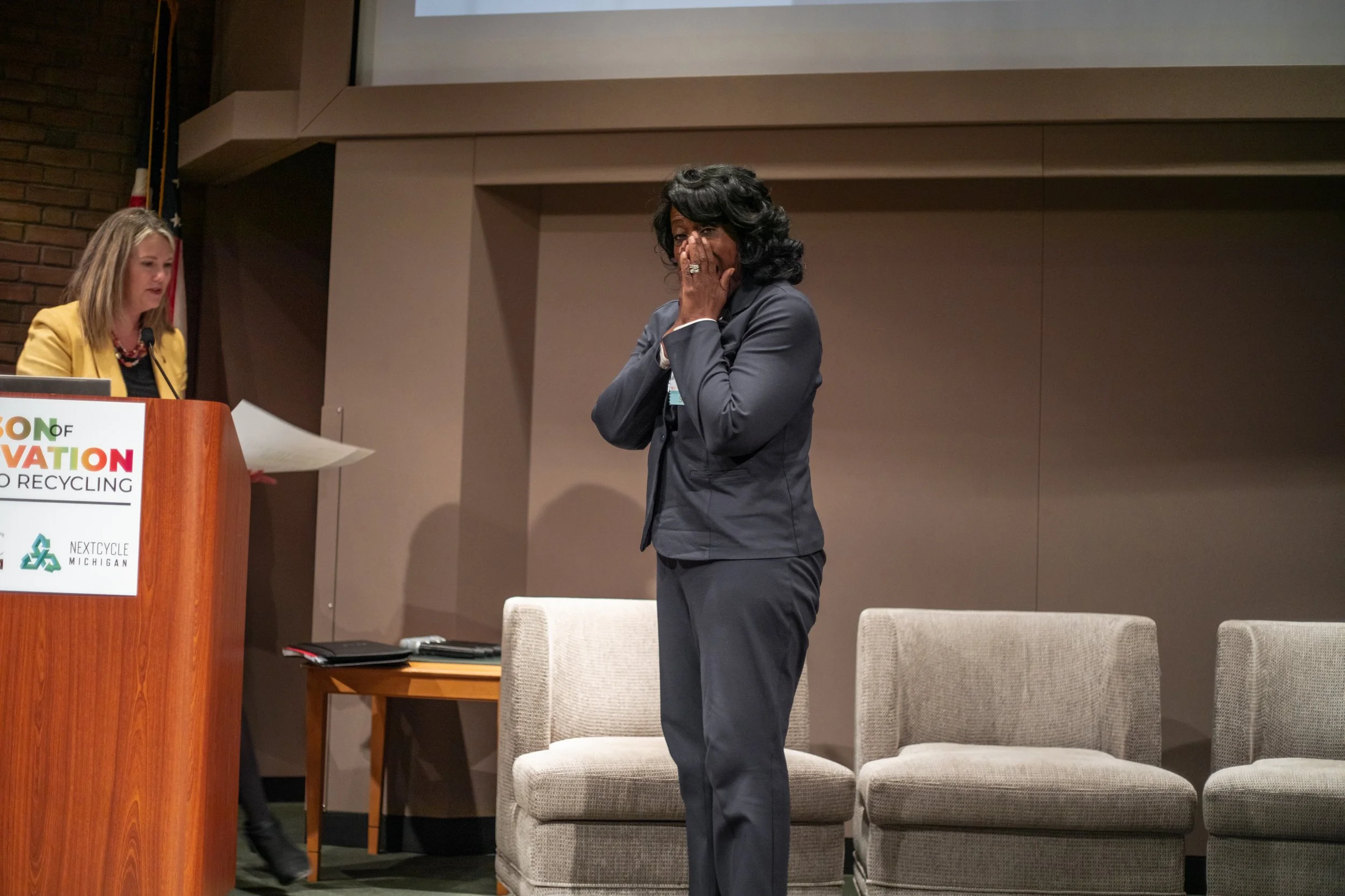 Two women on a presentation stage.
