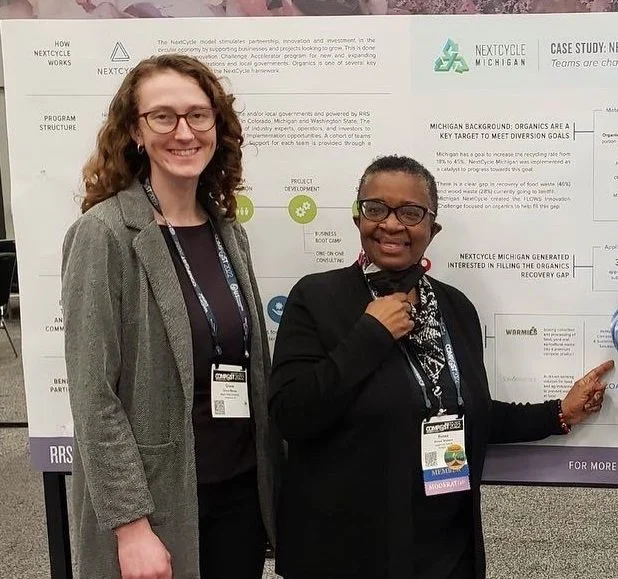 Two women in front of a foam board presentation