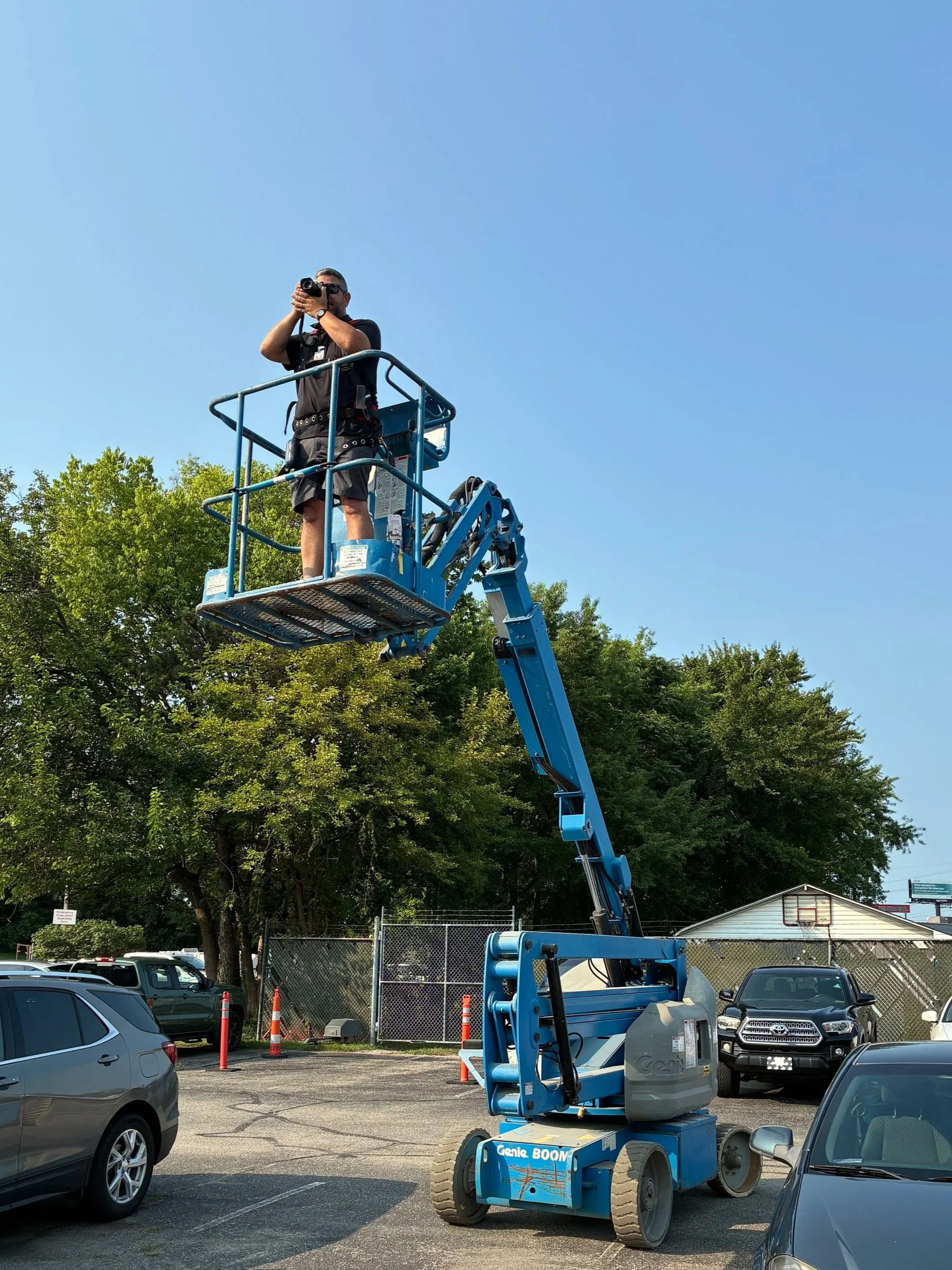 Miguel Monroy photographing CEPEDA employees from a boom lift during the full-company group portrait