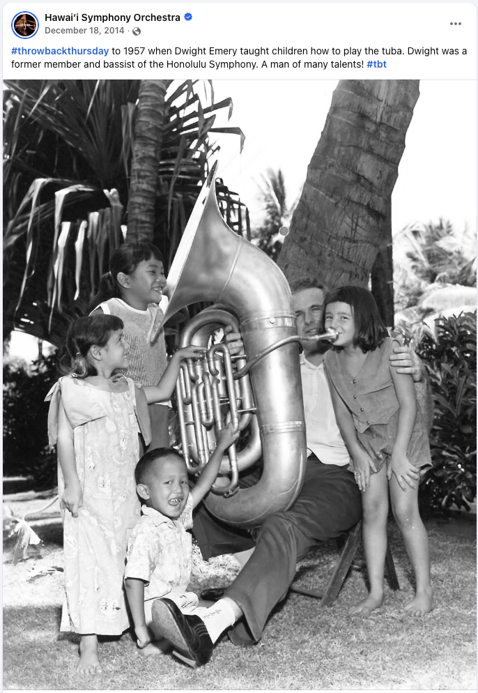 Hawaiʻi Symphony Orchestra Facebook post featuring a 1957 black-and-white photograph of musician Dwight Emery showing children how to play a tuba.