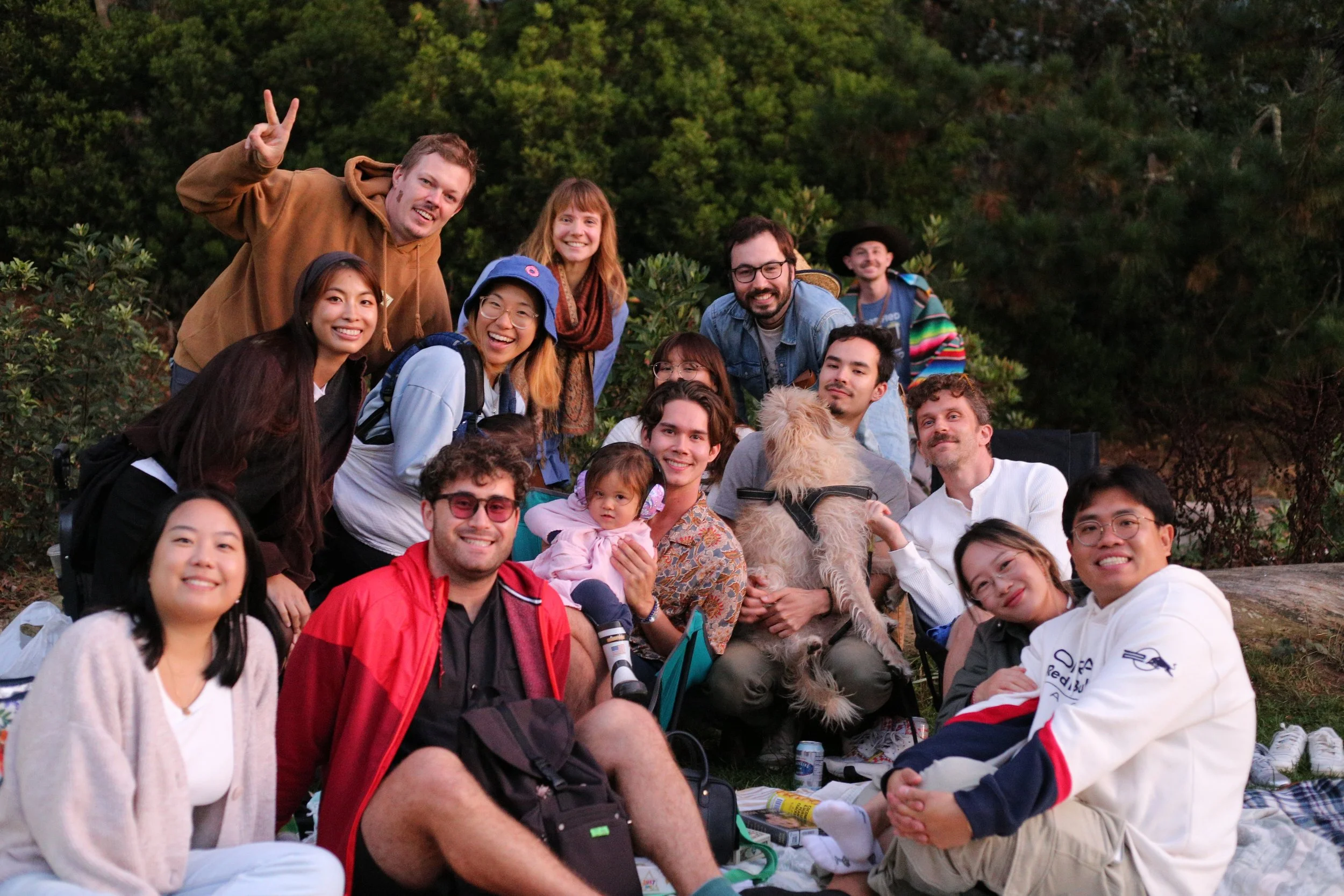 David Pierce poses with friends and a dog during an outdoor gathering at Golden Gate Park