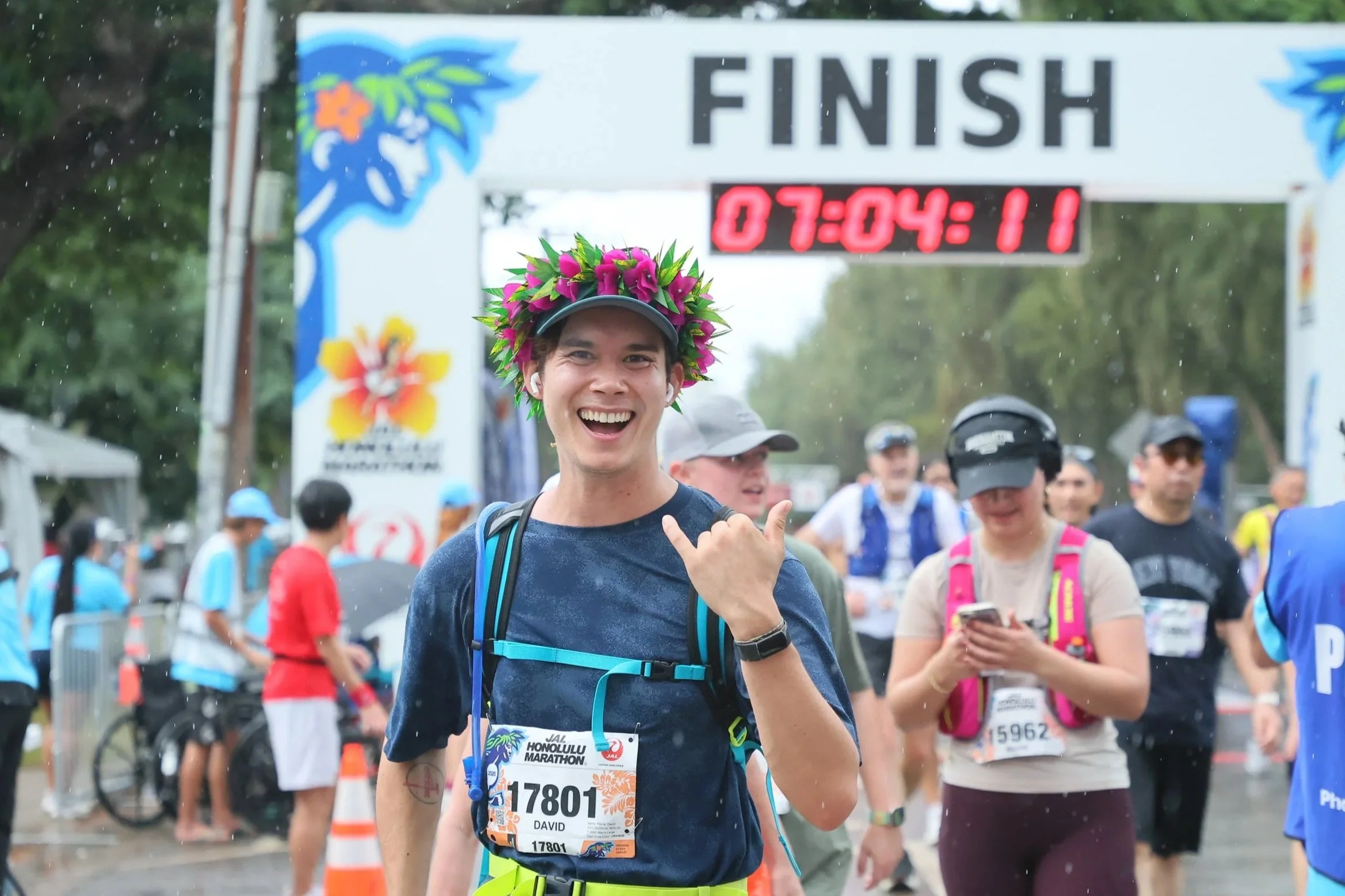 David Pierce crosses the finish line of the Honolulu Marathon wearing a flower crown (lei po'o).