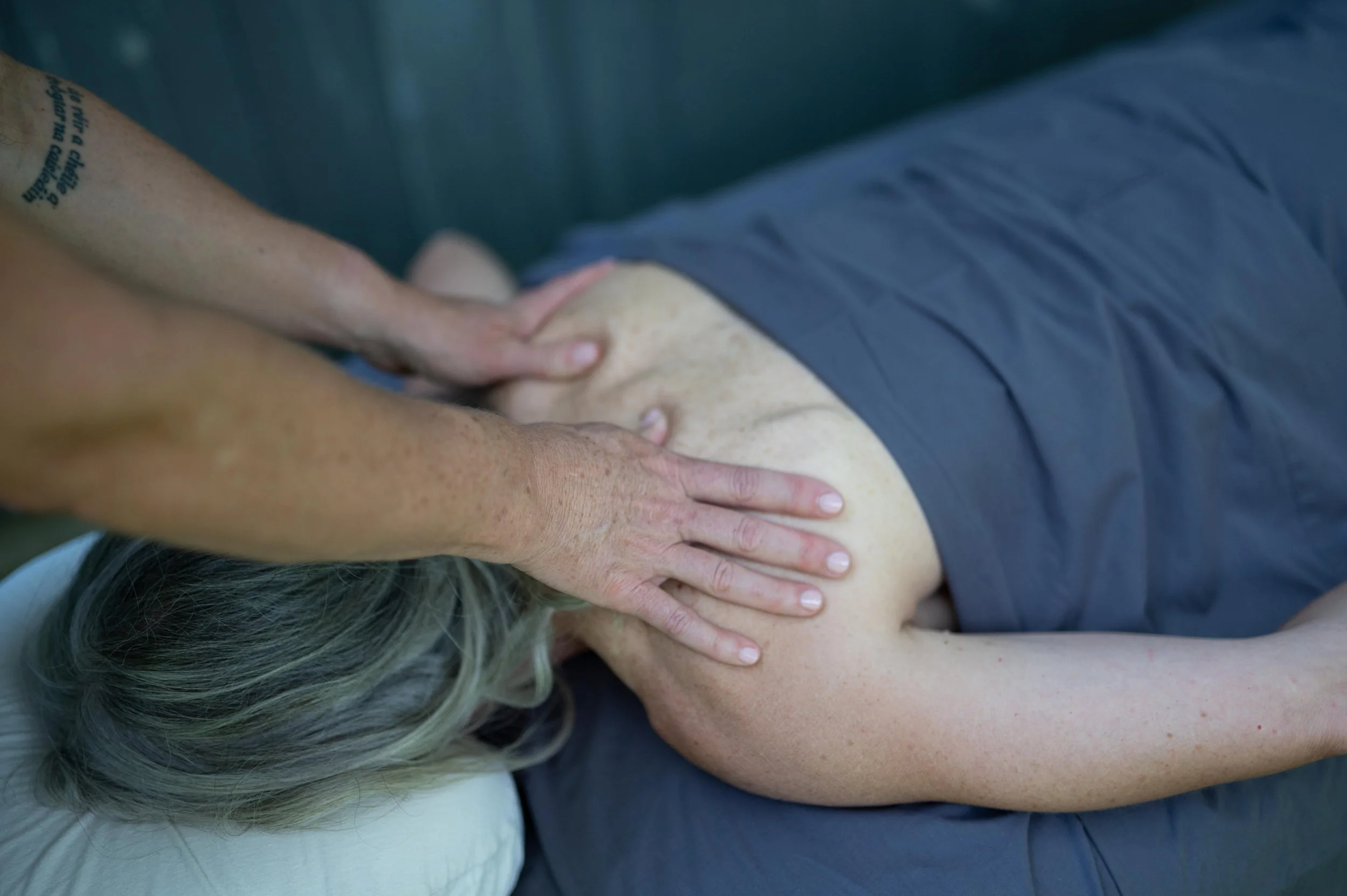 Person receiving a massage on their back with a massage therapist's hands applying pressure.