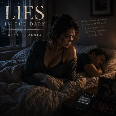 A woman sits on a bed looking at her phone while a man sleeps next to her. The room is dimly lit with a window in the background, and there is a small mirror or picture on a nightstand.