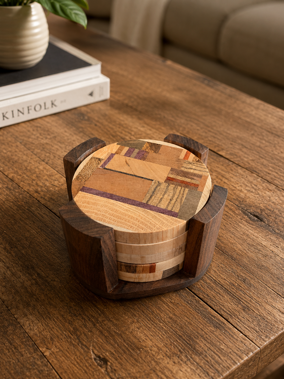 A round wooden box with a multicolored patchwork design on its lid, placed on a wooden table.