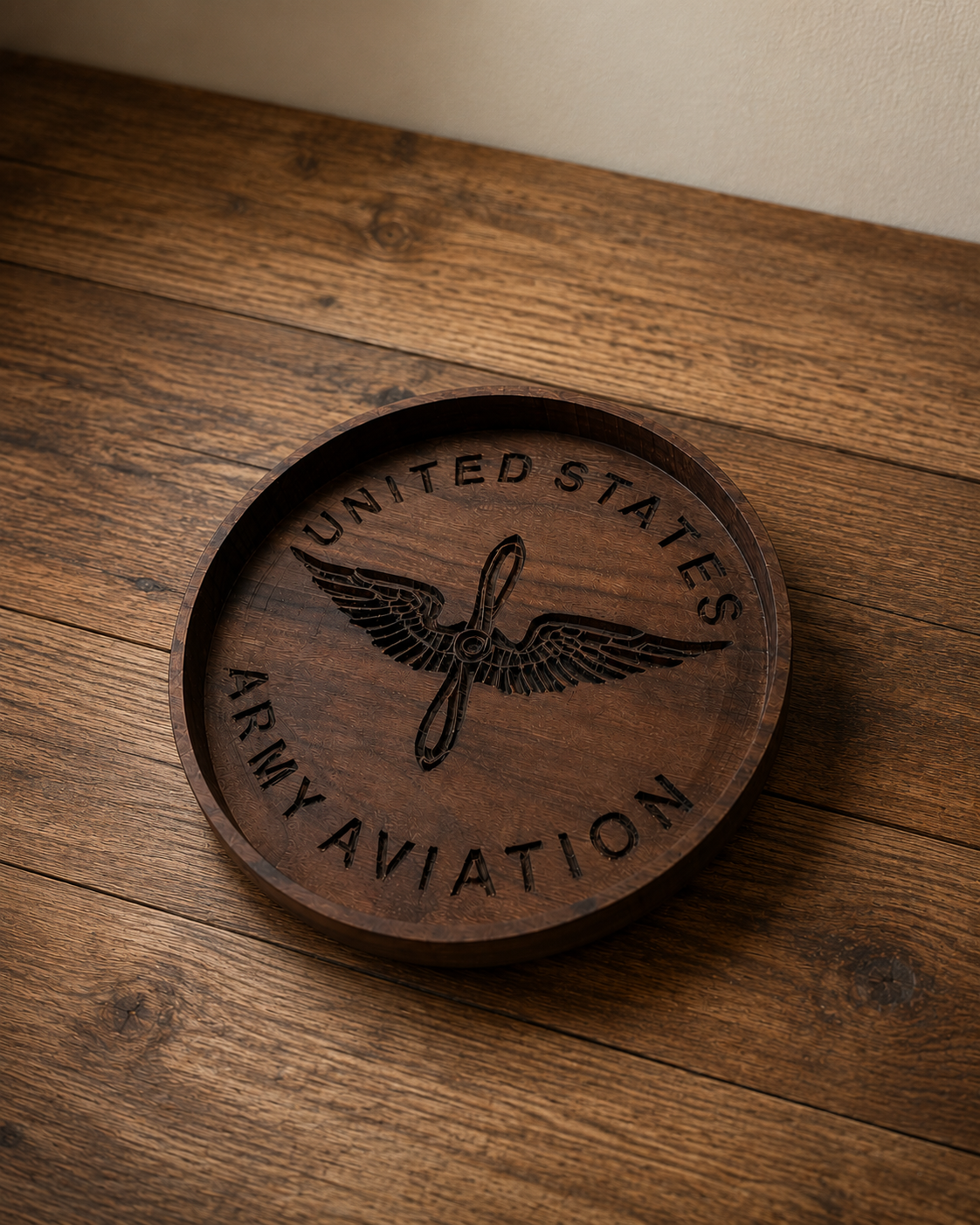 Wooden clock with engraved U.S. Army Aviation emblem, including wings and propeller, on a wooden surface.