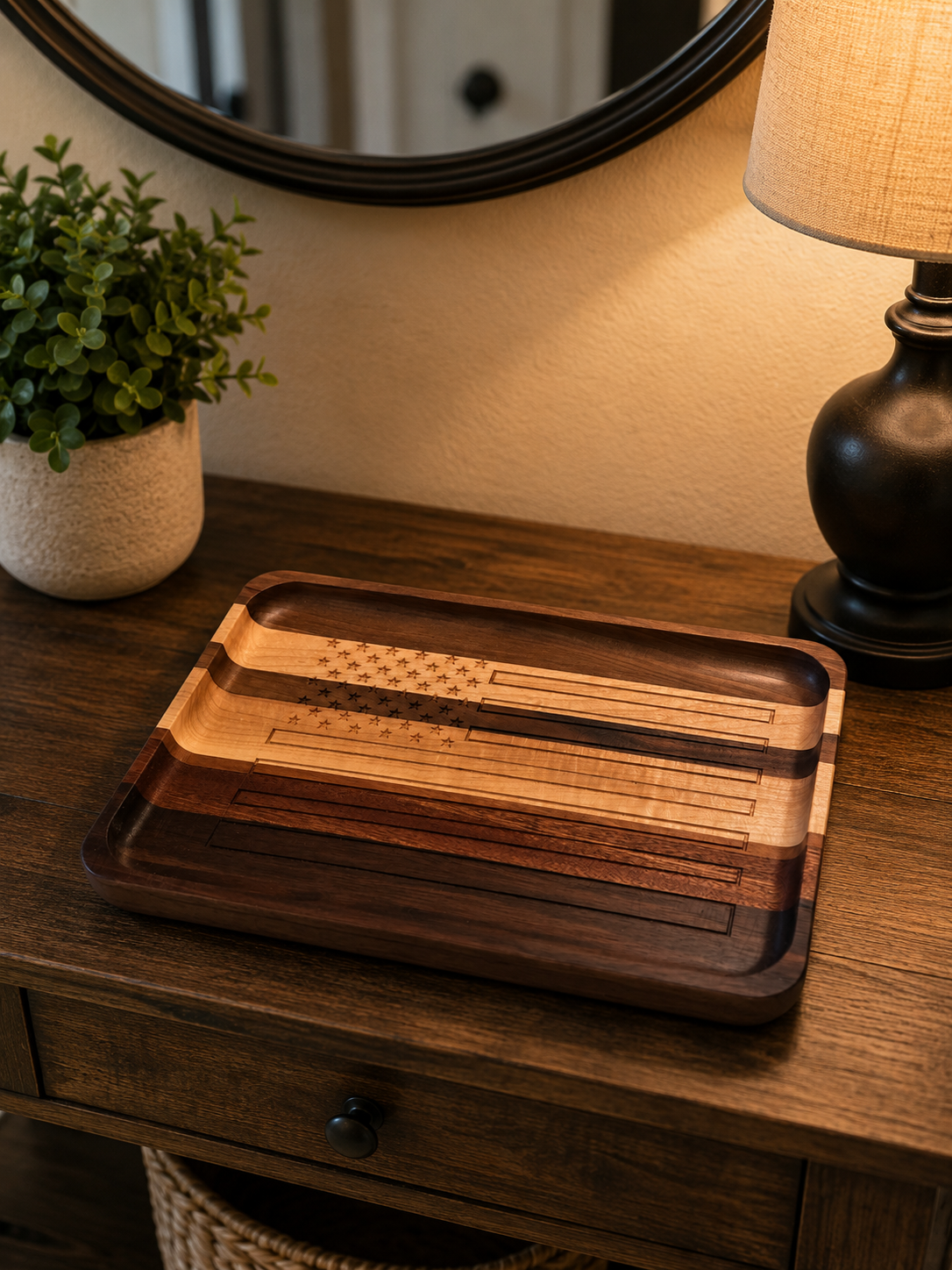 Wooden tray with an American flag design on a wooden table, with a potted green plant and a table lamp nearby.