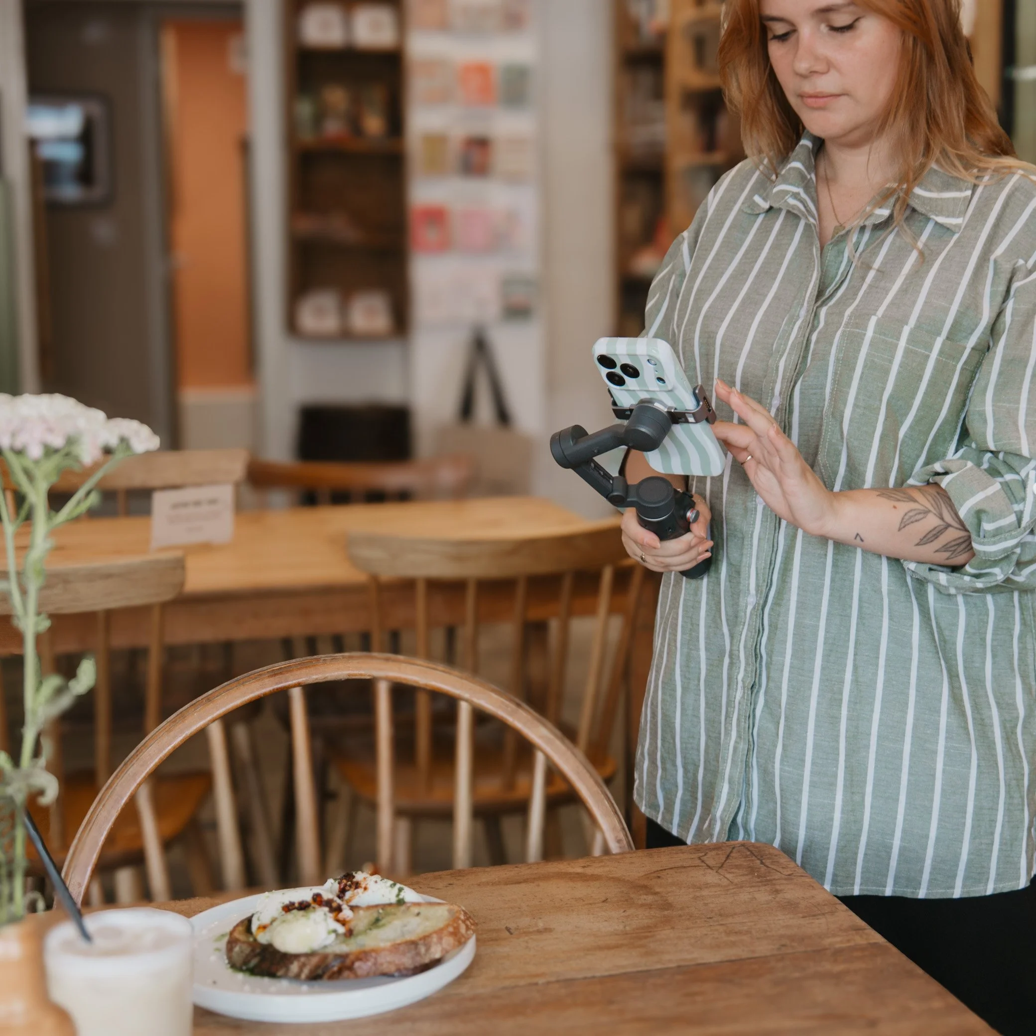 Leah Croft, creating content at a cosy cafe for a small businesses across Cornwall
