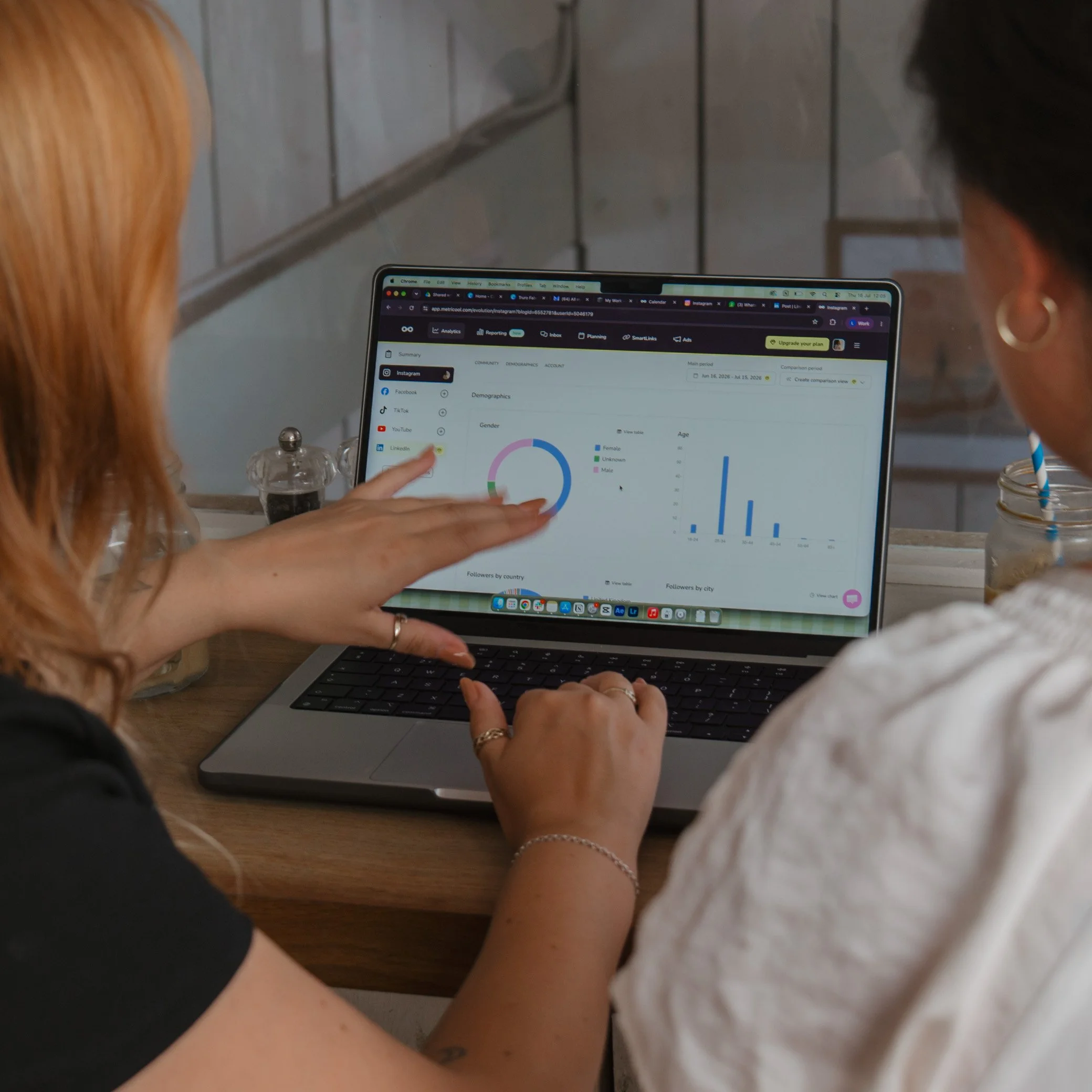 Leah reviewing data on a laptop screen in a casual environment. Monthly social media management for Cornwall small businesses.