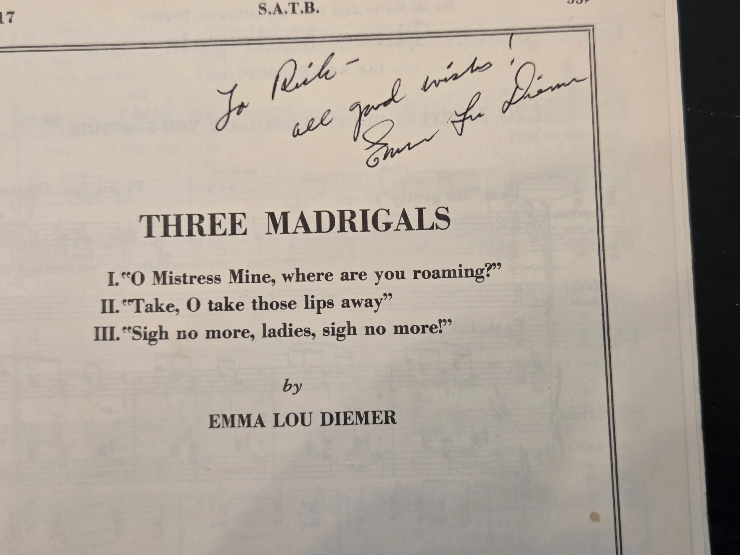 Page from a book titled 'Three Madrigals' with handwritten note at the top that reads 'To Risha, all good wishes' signed 'Emma Lou Diemer.' Below the title, there is a dialogue excerpt.