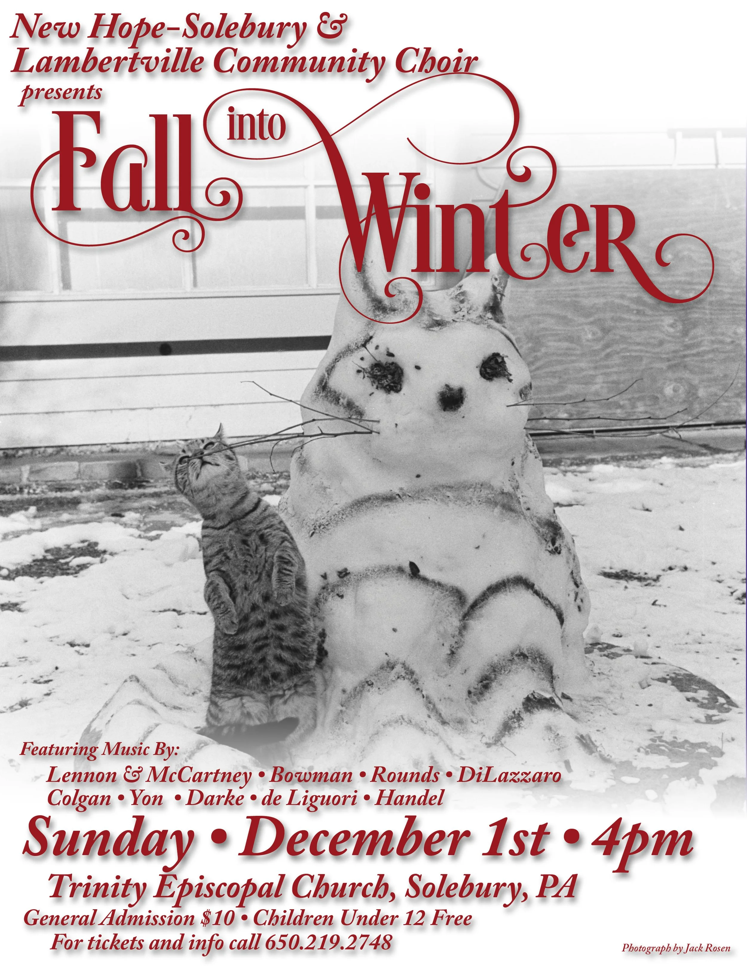 A black-and-white photo of a snowman with dark features and a small animal, possibly a kitten, next to it in a snowy outdoor setting. The background includes a fence and a building.