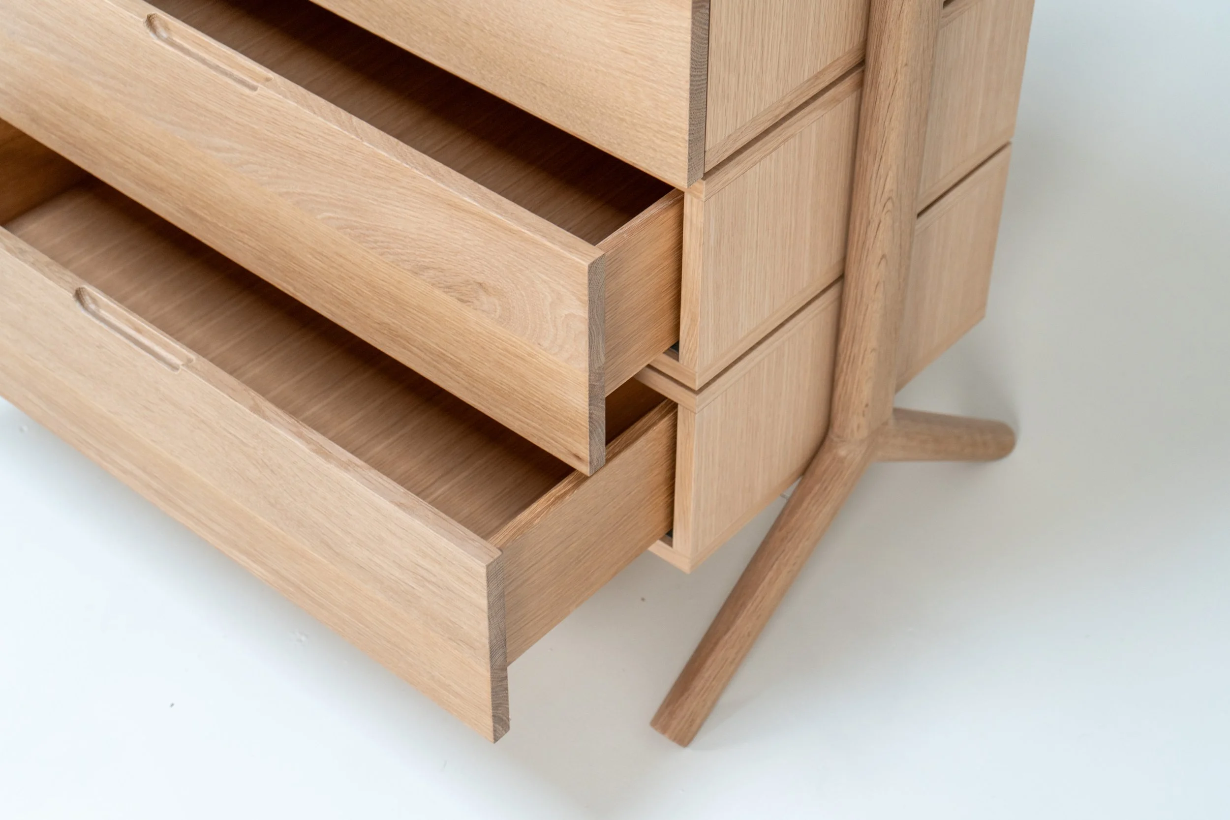 Close-up view of a wooden dresser with open drawers showcasing its natural wood finish and craftsmanship.