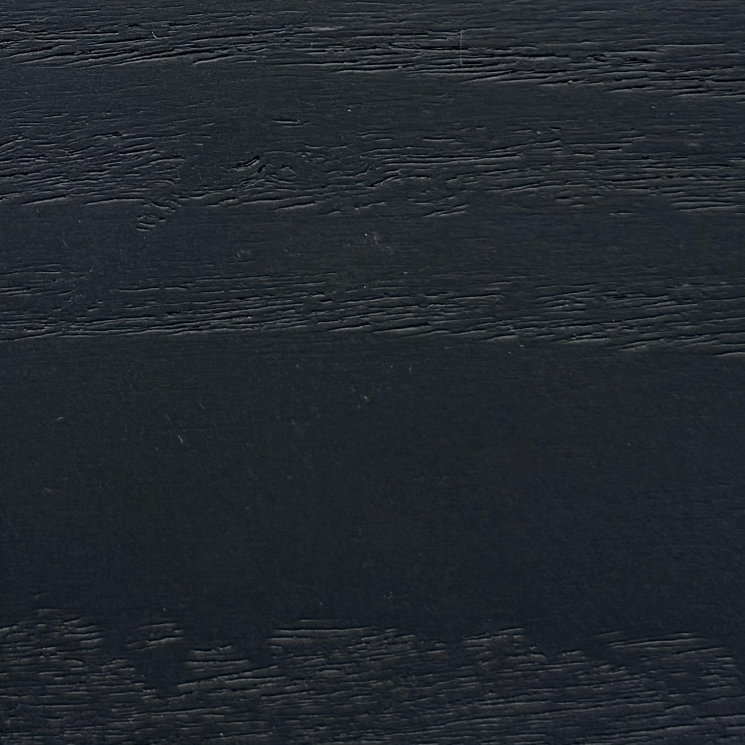 Close-up of a black wooden surface with visible wood grain and texture.