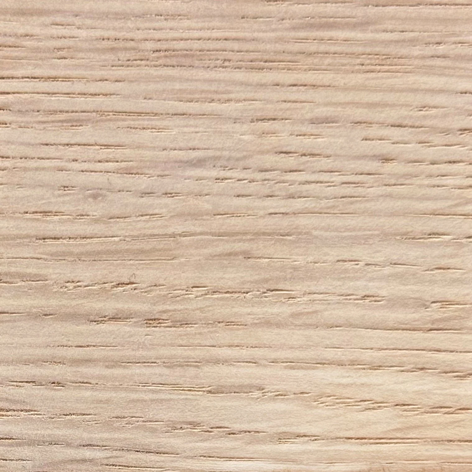 Close-up of a light-colored wooden surface with horizontal grain lines.