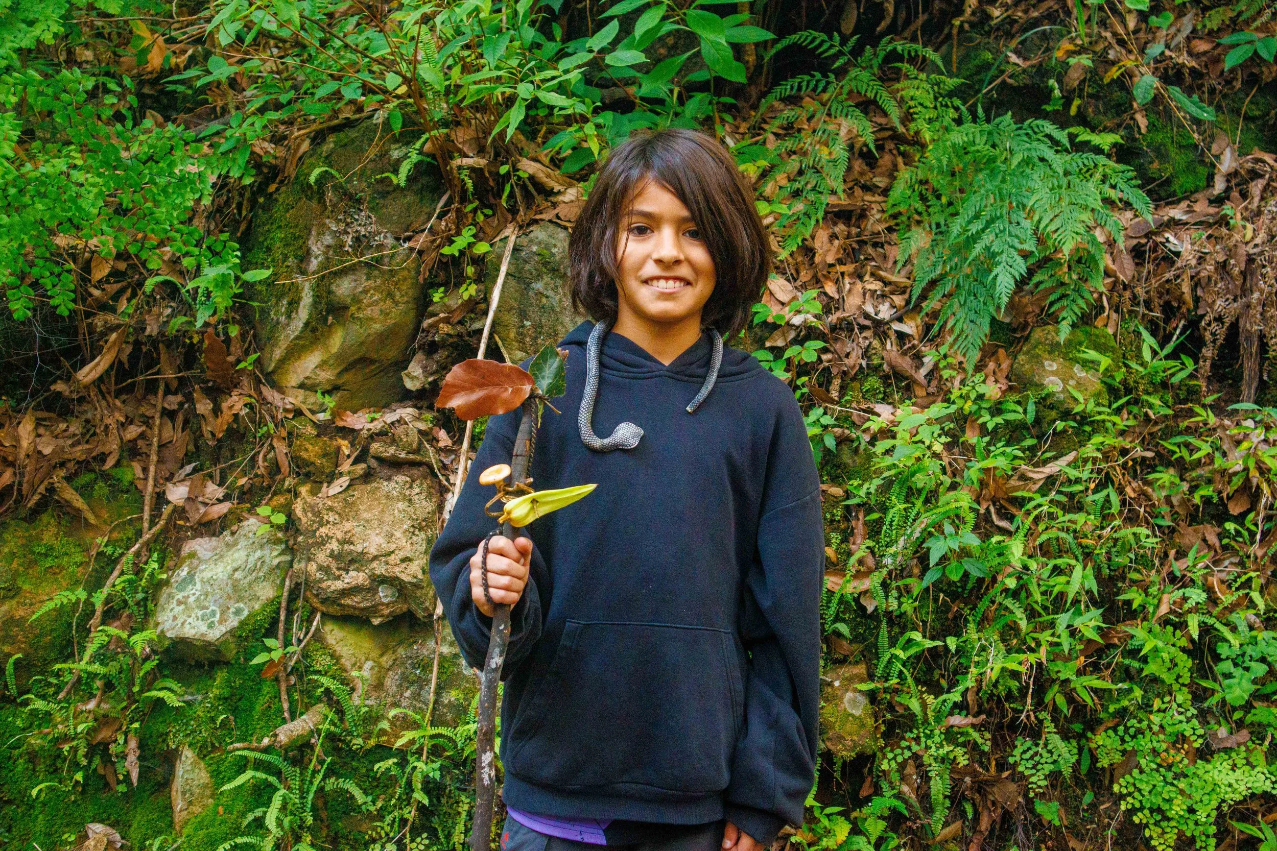 Joven con cinturón de herramientas en un bosque.