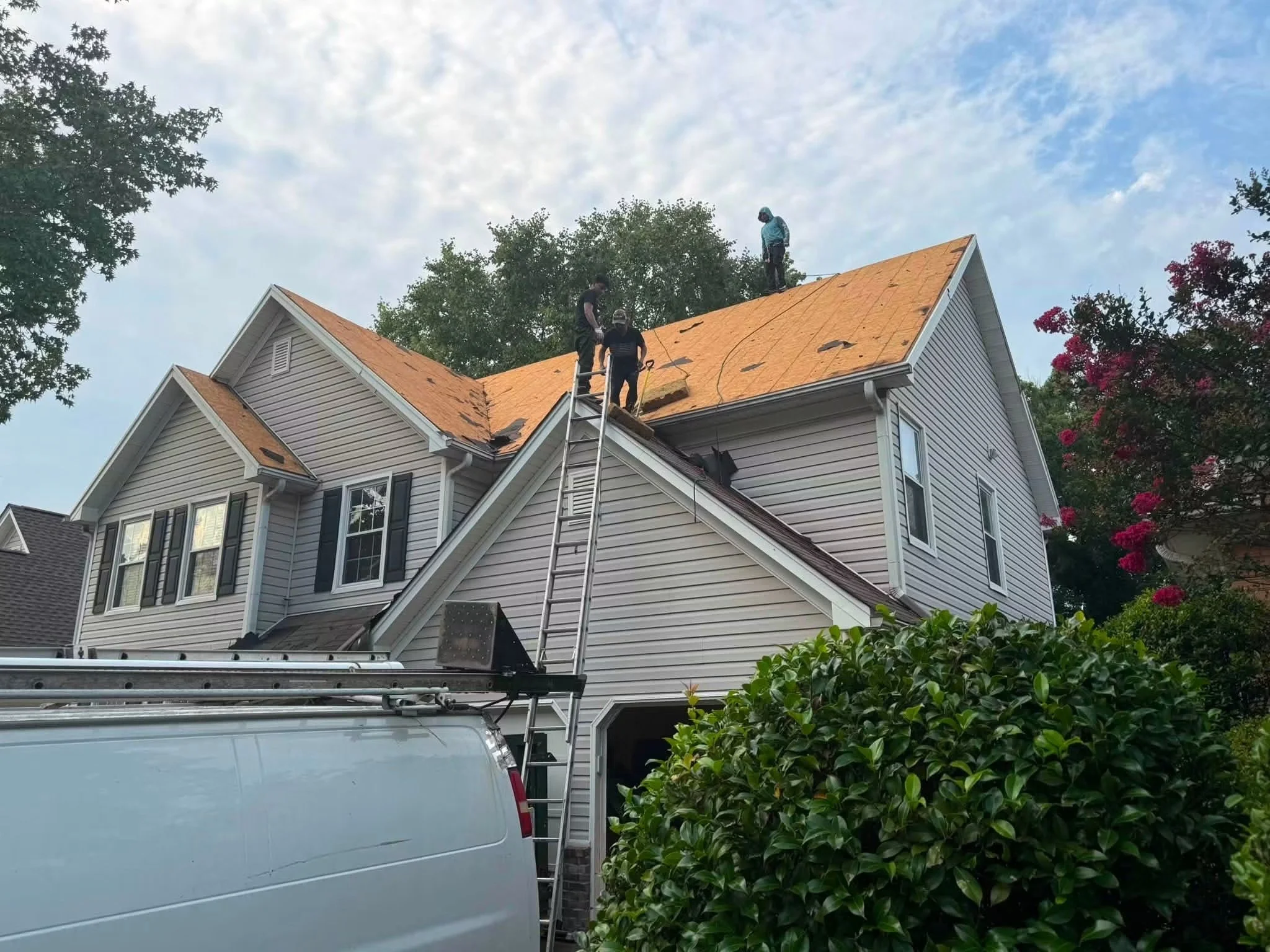 Crew installing new shingles during a roof replacement