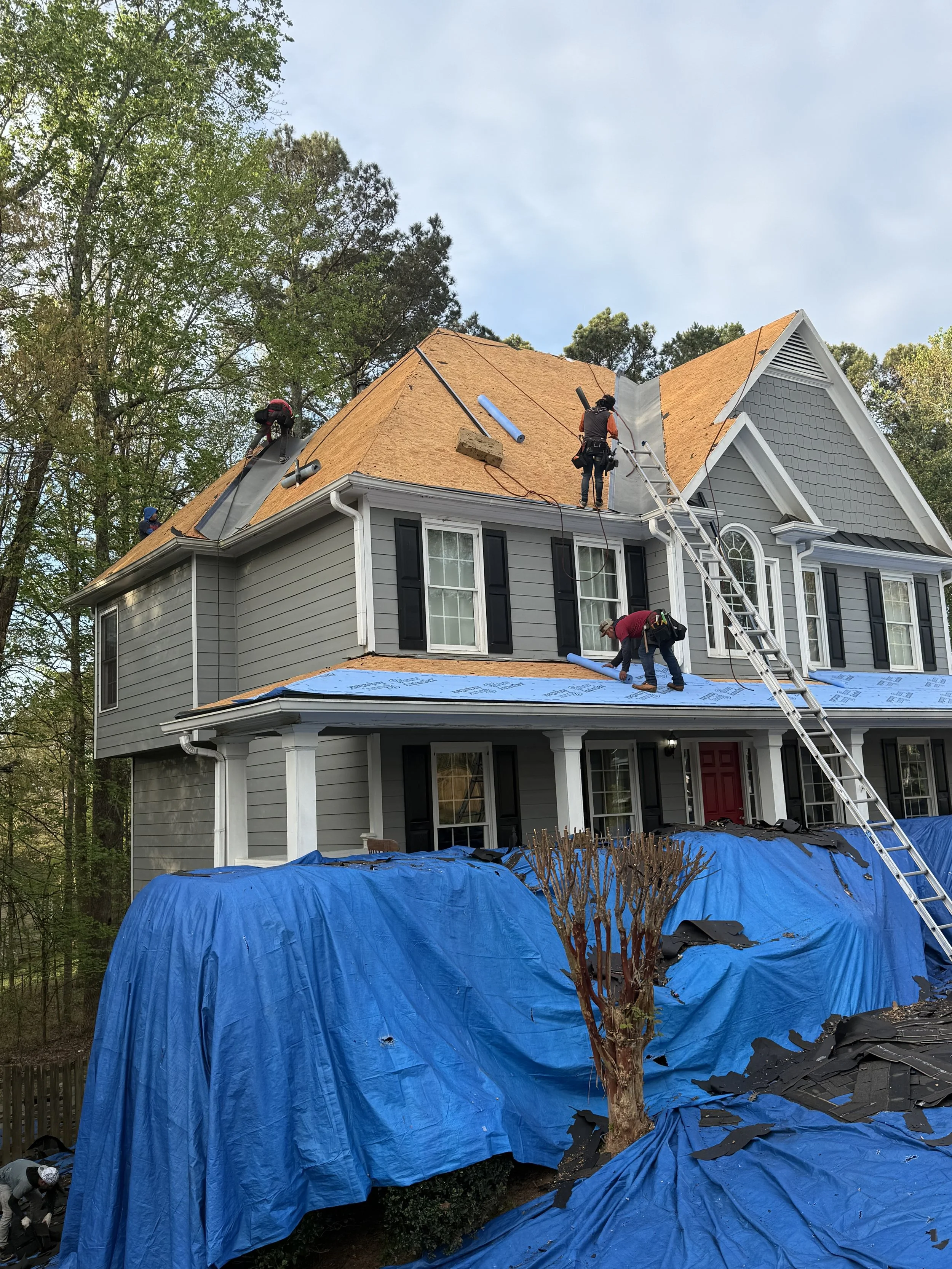 Workers replacing the roof of a two-story house in Metro Atlanta