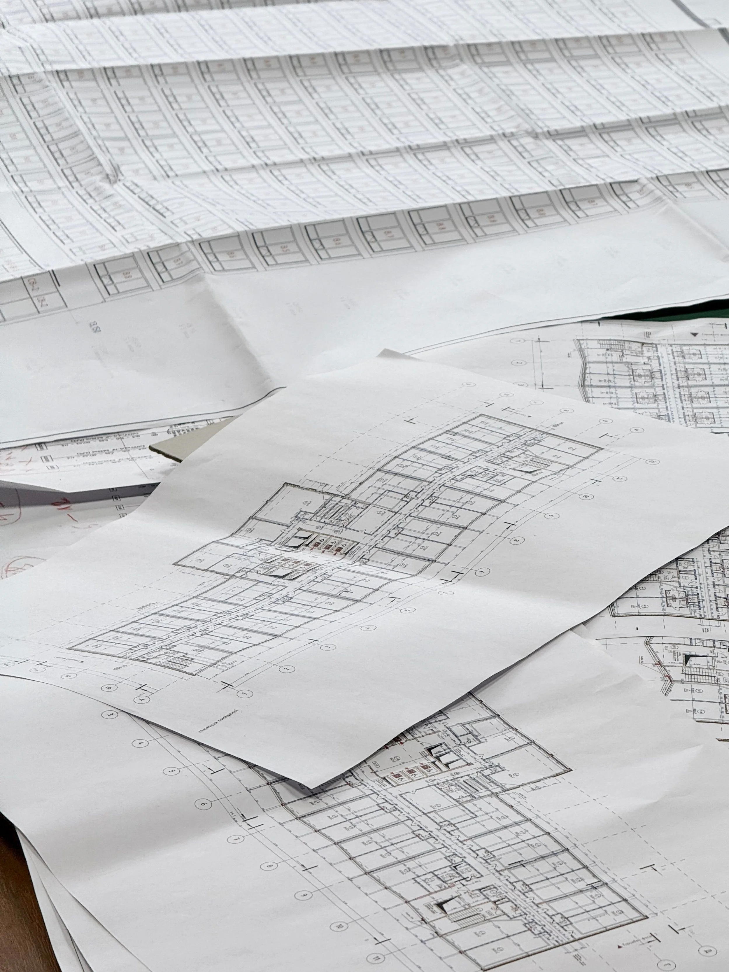 Architectural blueprints and construction plans spread out on a table.