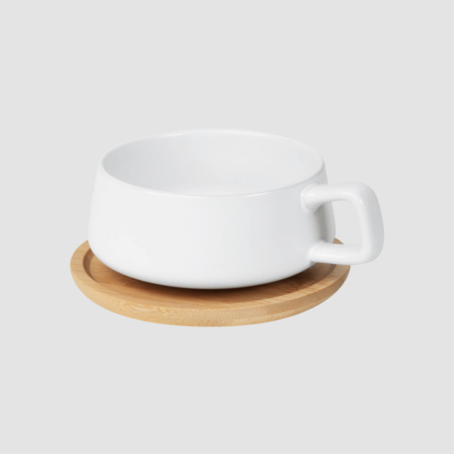Taza blanca en plato de madera