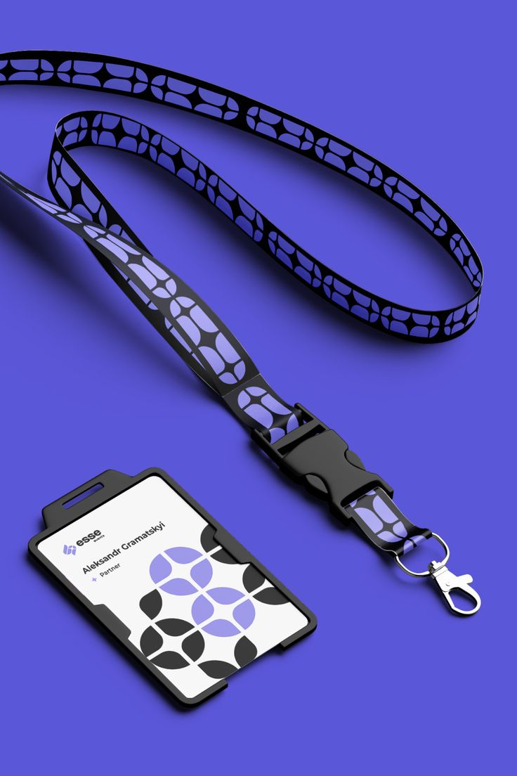 Lanyard con diseño de círculos y tonos morados con negro, y tarjeta de identificación.