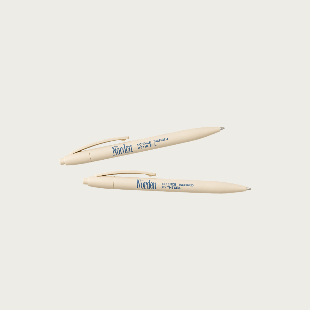 Bolígrafos corporativos personalizados en color crema con impresión del logotipo de Norden, ideales para kits corporativos, onboarding de colaboradores, eventos y productos de marca para empresas.