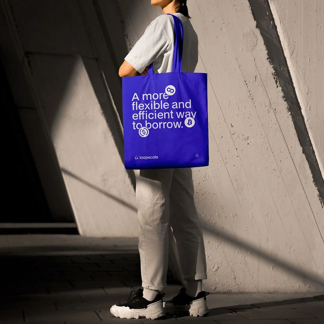 Bolsa de tela personalizada como parte de una campaña de marca, con logotipos y diseño impreso, utilizada en un entorno urbano como artículo promocional.