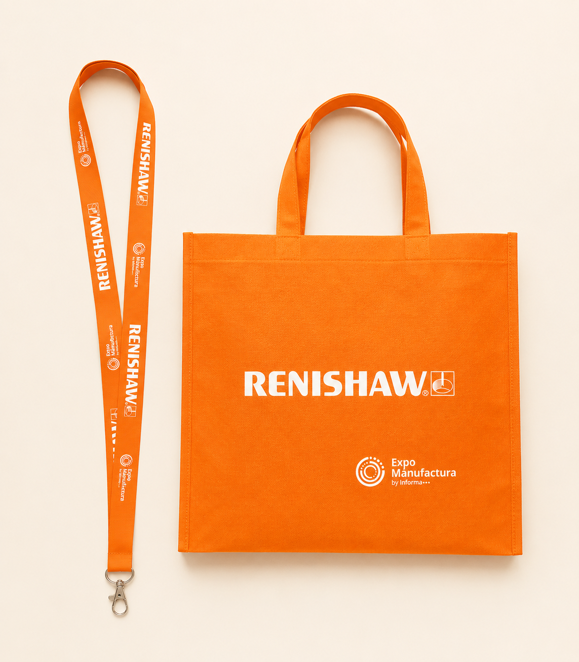 Bolsa de tela naranja con el logo de Renishaw y texto promocional, junto a un lanyard naranja con texto y logotipo, todos relacionados con una feria de manufactura.