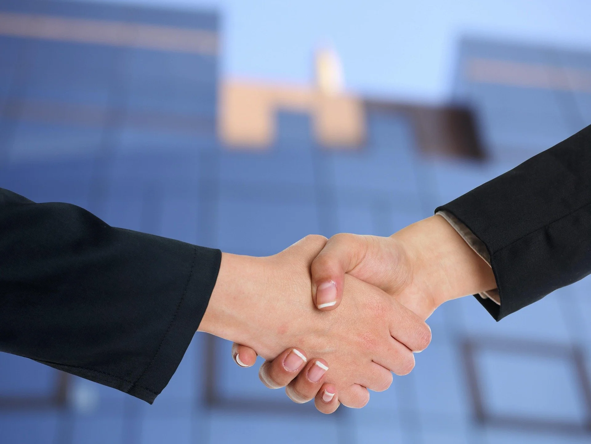 Two business partners shaking hands during a hotel investment sale