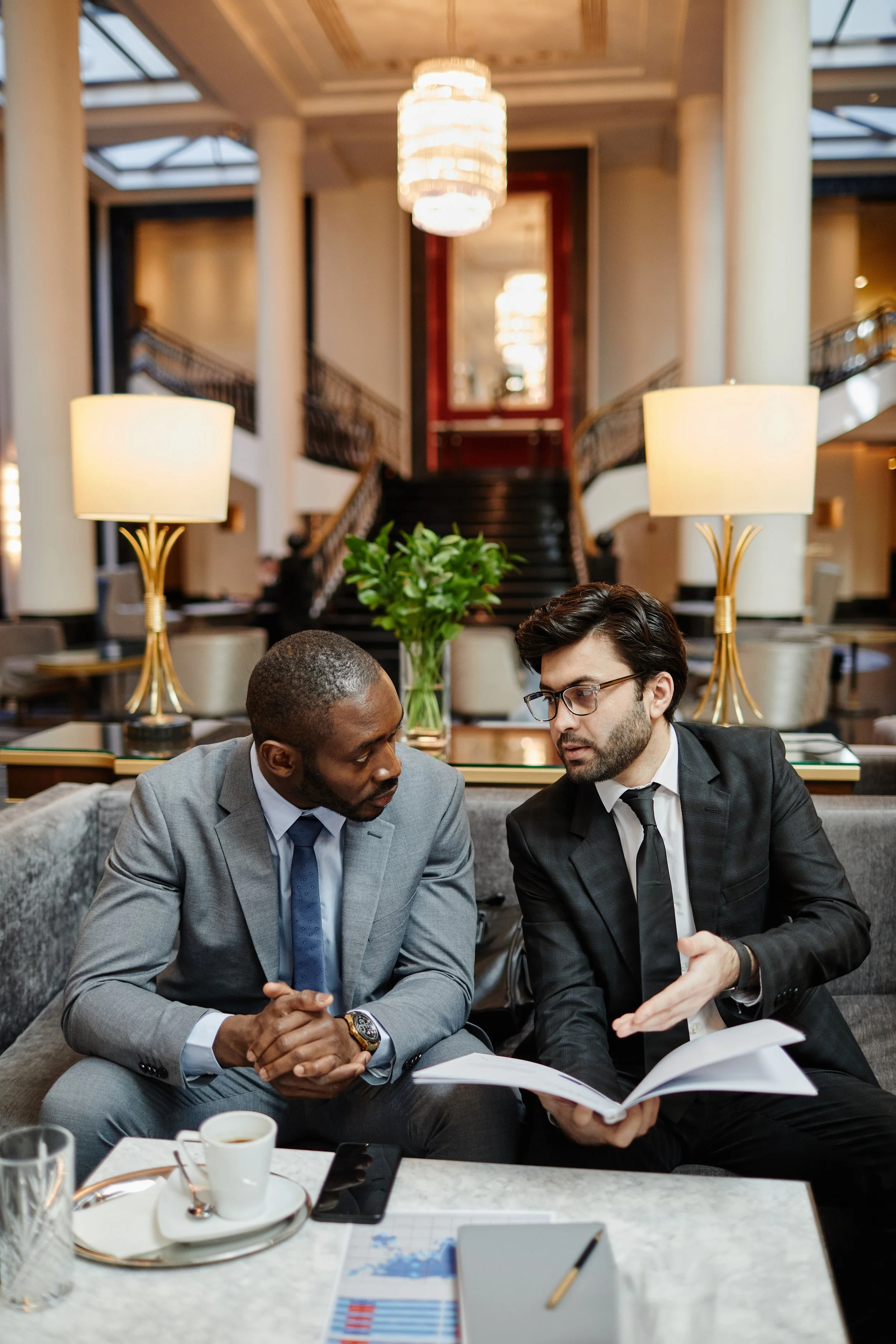 Hotel broker and potential hotel investor meeting in a hotel lobby to discuss hotel investment sales