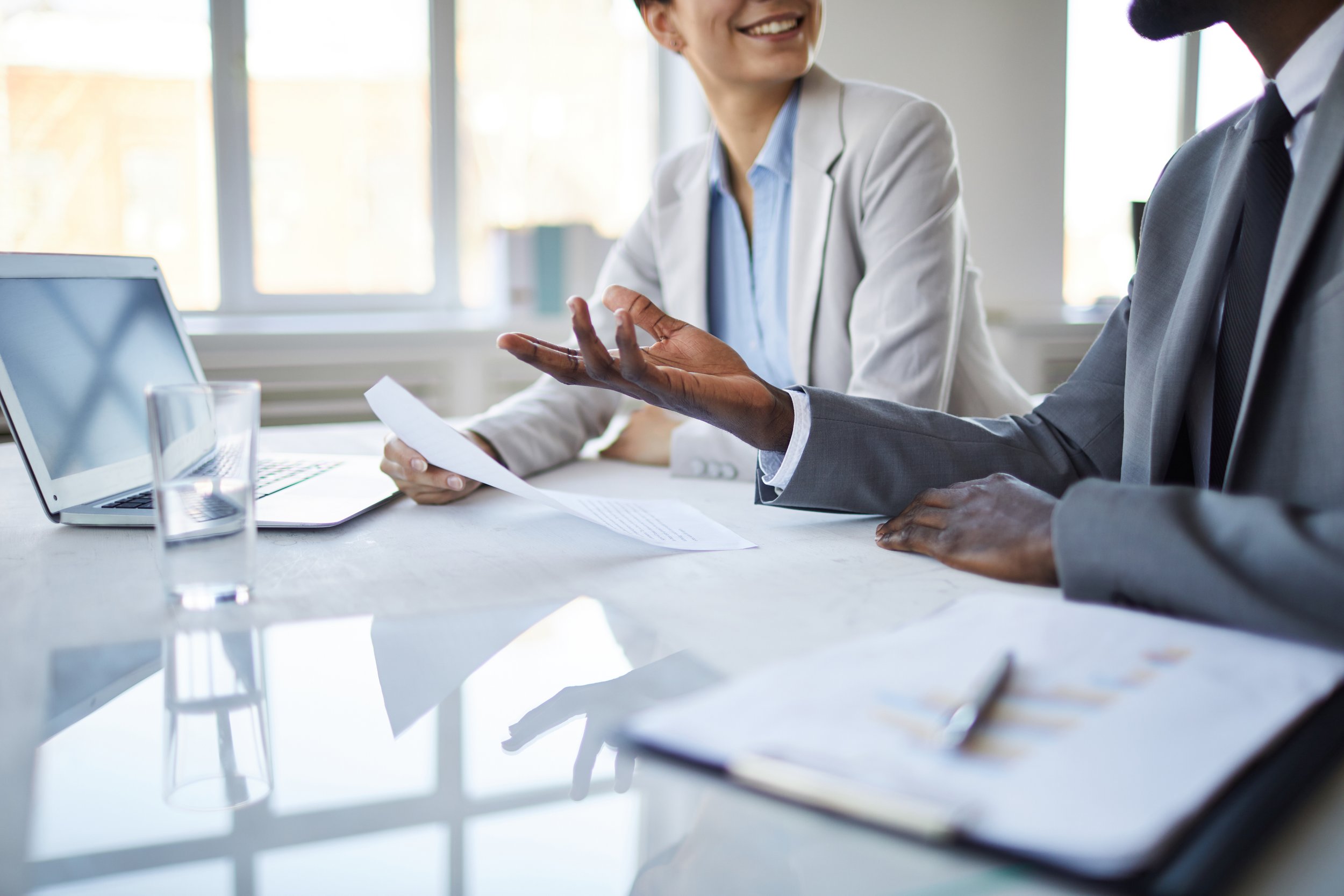 Commercial real estate agent and hotel owner sitting at a table discussing strategy and real estate investment opportunities