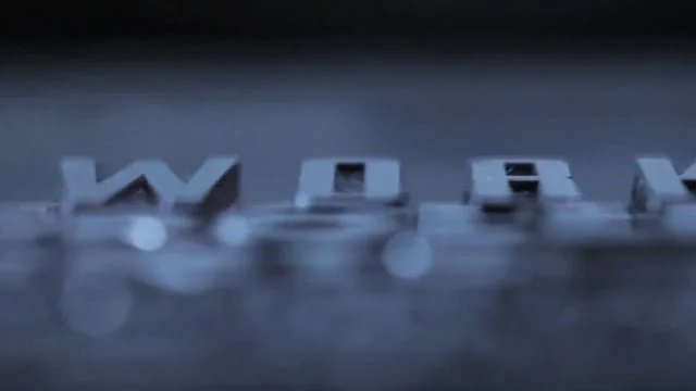 Close-up of metallic letters spelling out 'WORV' on a reflective surface.