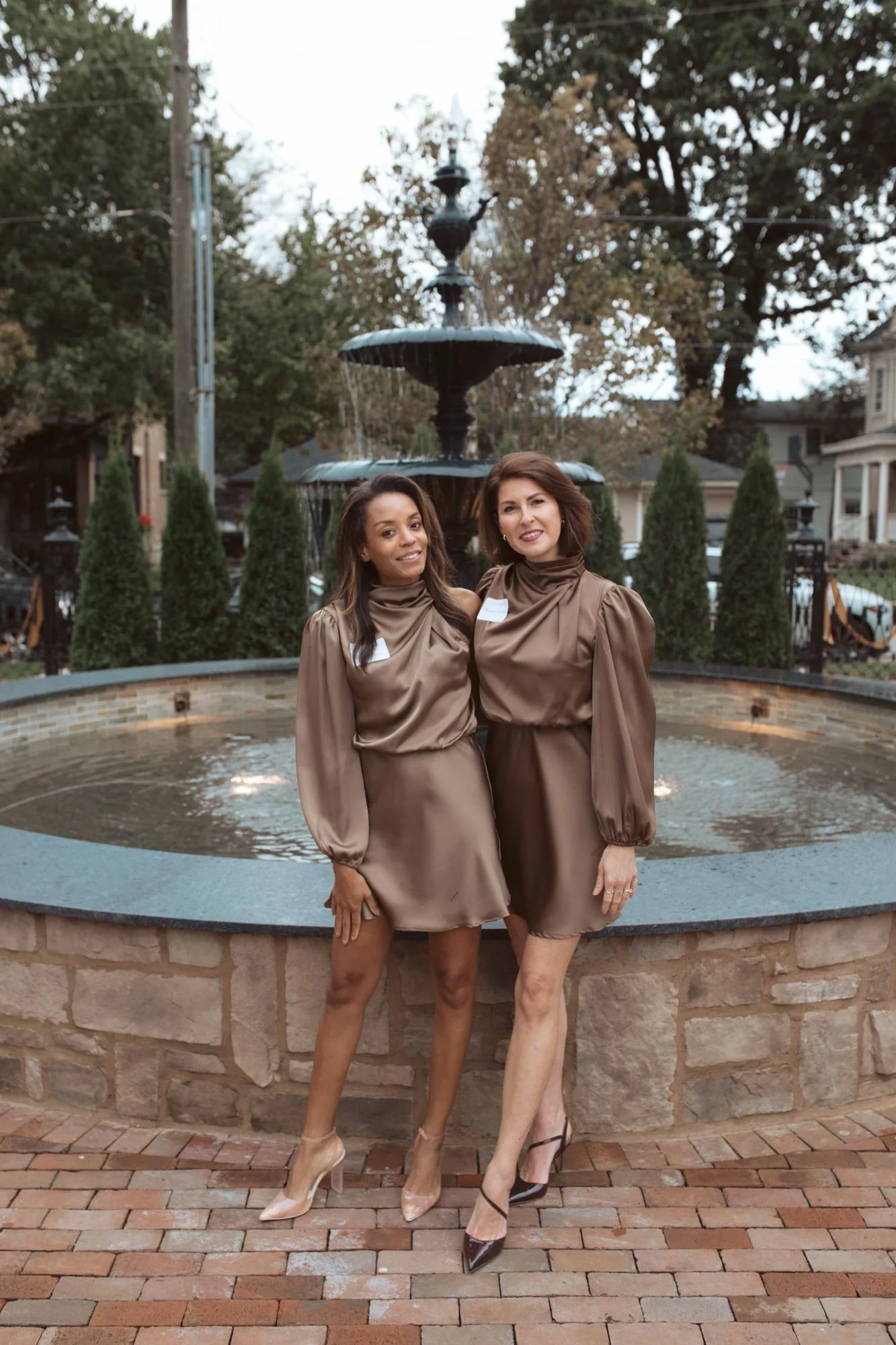 Two guests standing in front of the courtyard fountain.