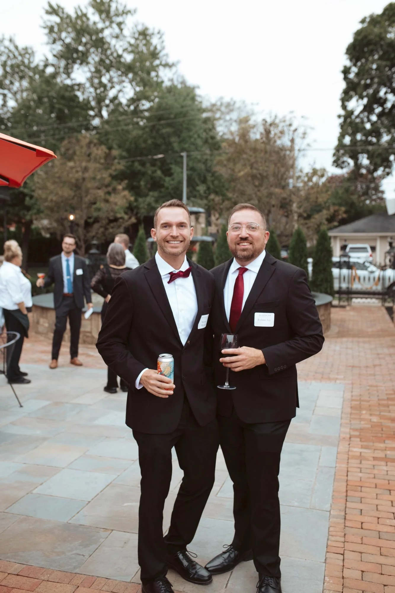 Two guests standing together in the brick courtyard.