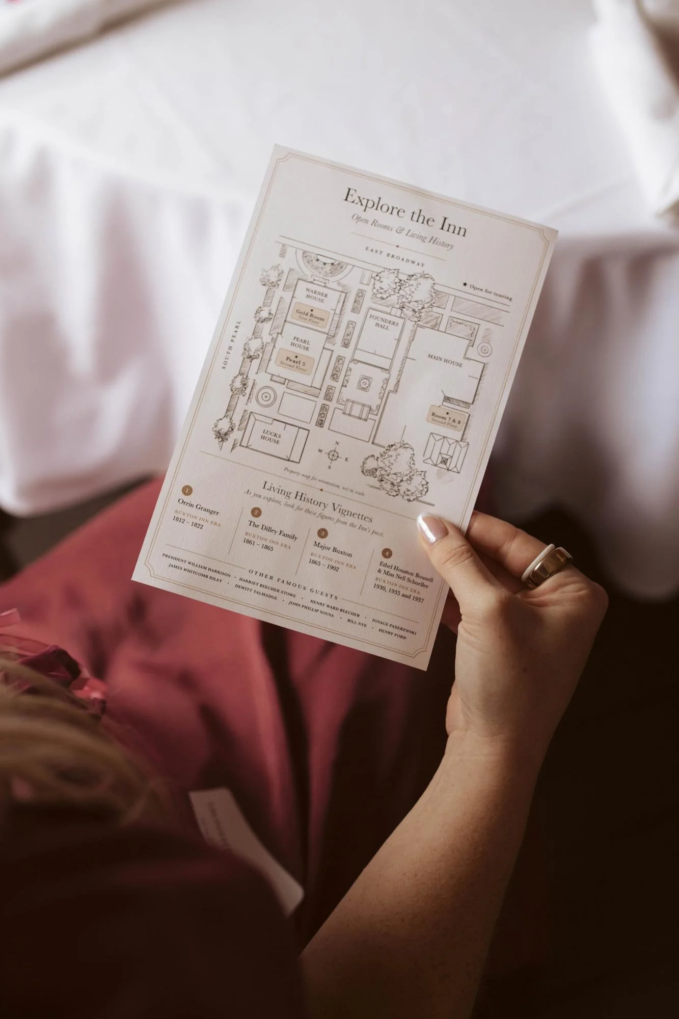A guest holding the illustrated Explore the Inn program and property map.