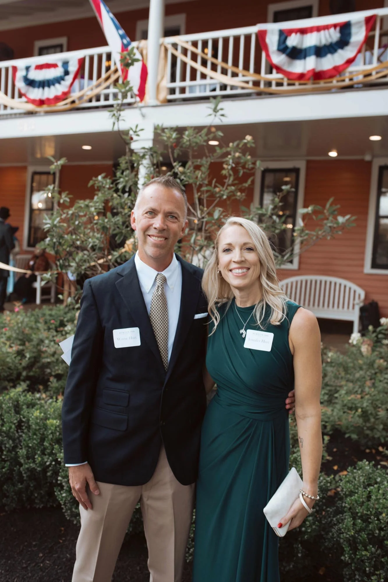 Two guests posing together in front of the decorated porch.