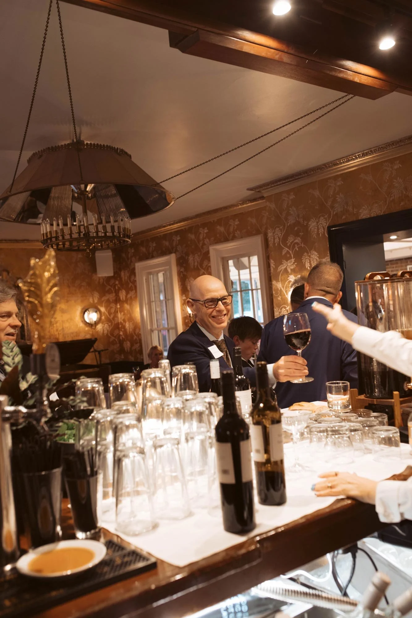 A guest raising a glass at the bar in the 1812 Lounge.